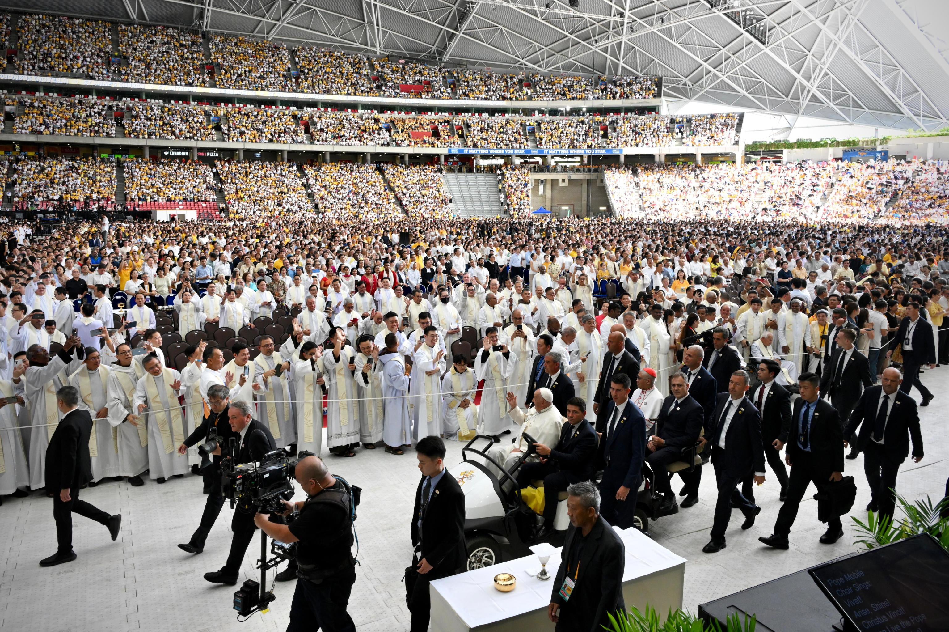 Pope Francis gestures to the Catholic faithful as he arrives to lead a holy mass at the National Stadium in Singapore on 12 September 2024