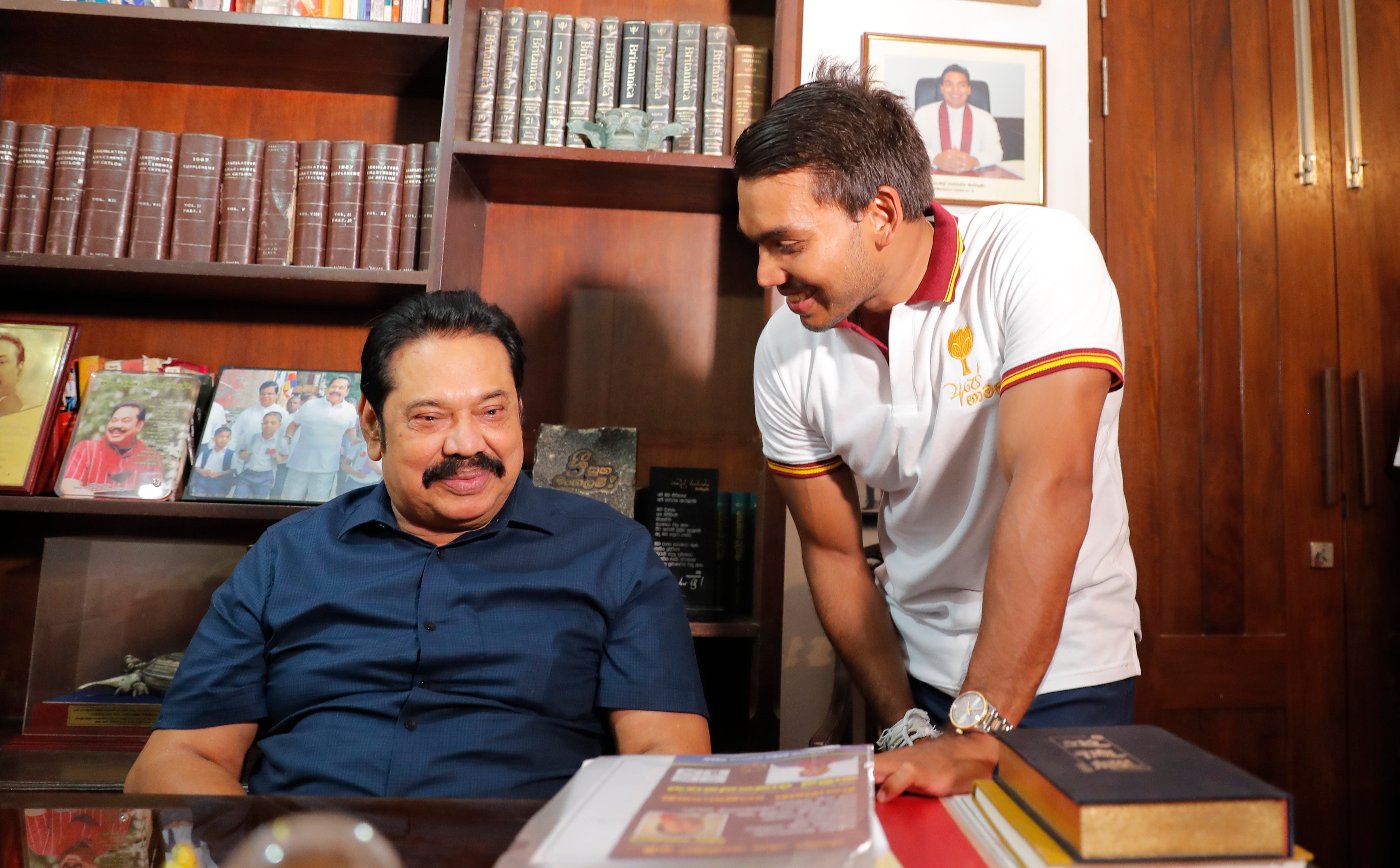 Former PM Mahinda Rajapaksa speaks with his lawmaker son Namal following his election victory in August 2020