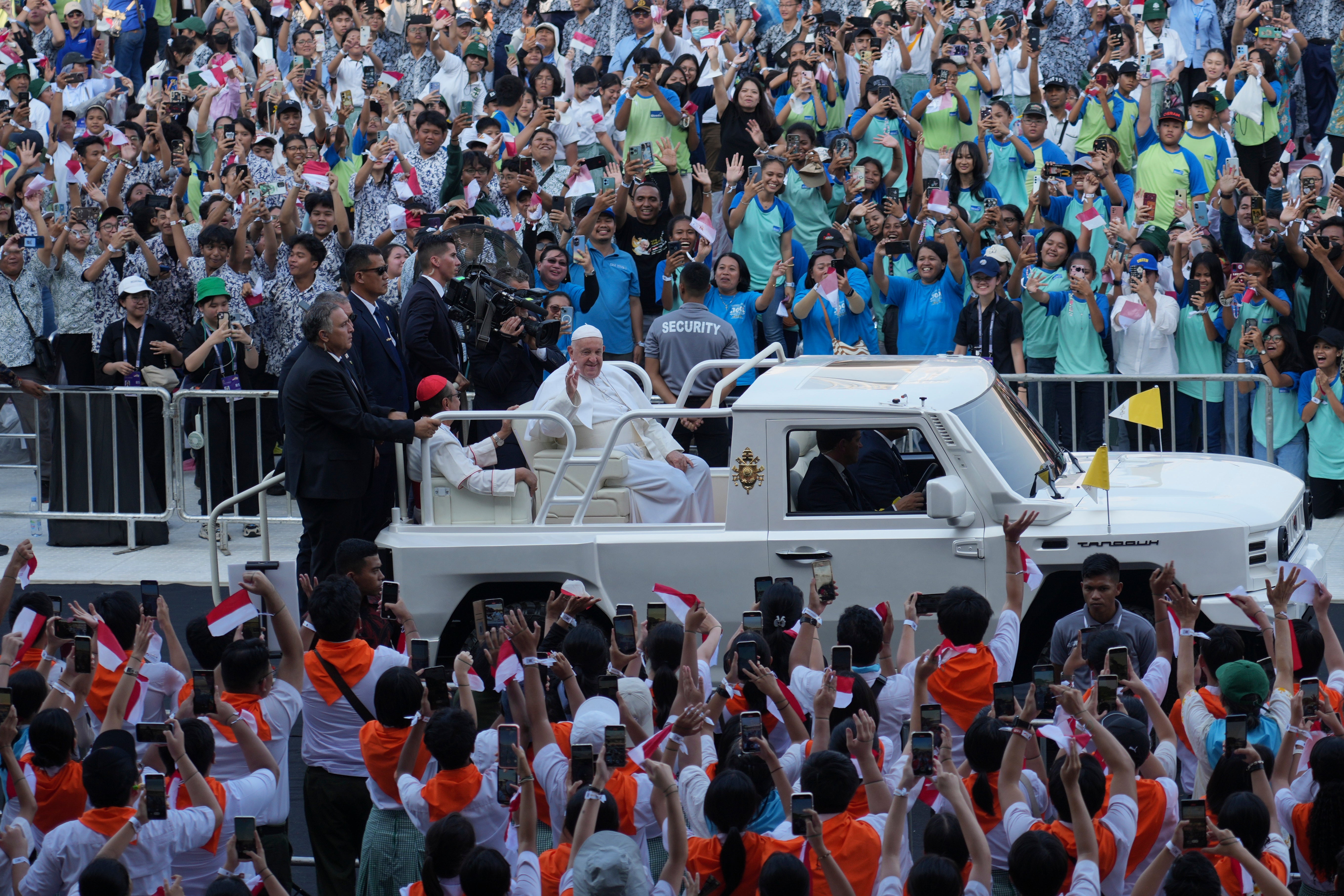 People cheer as Pope Francis arrives at Madya Stadium in Jakarta, Indonesia