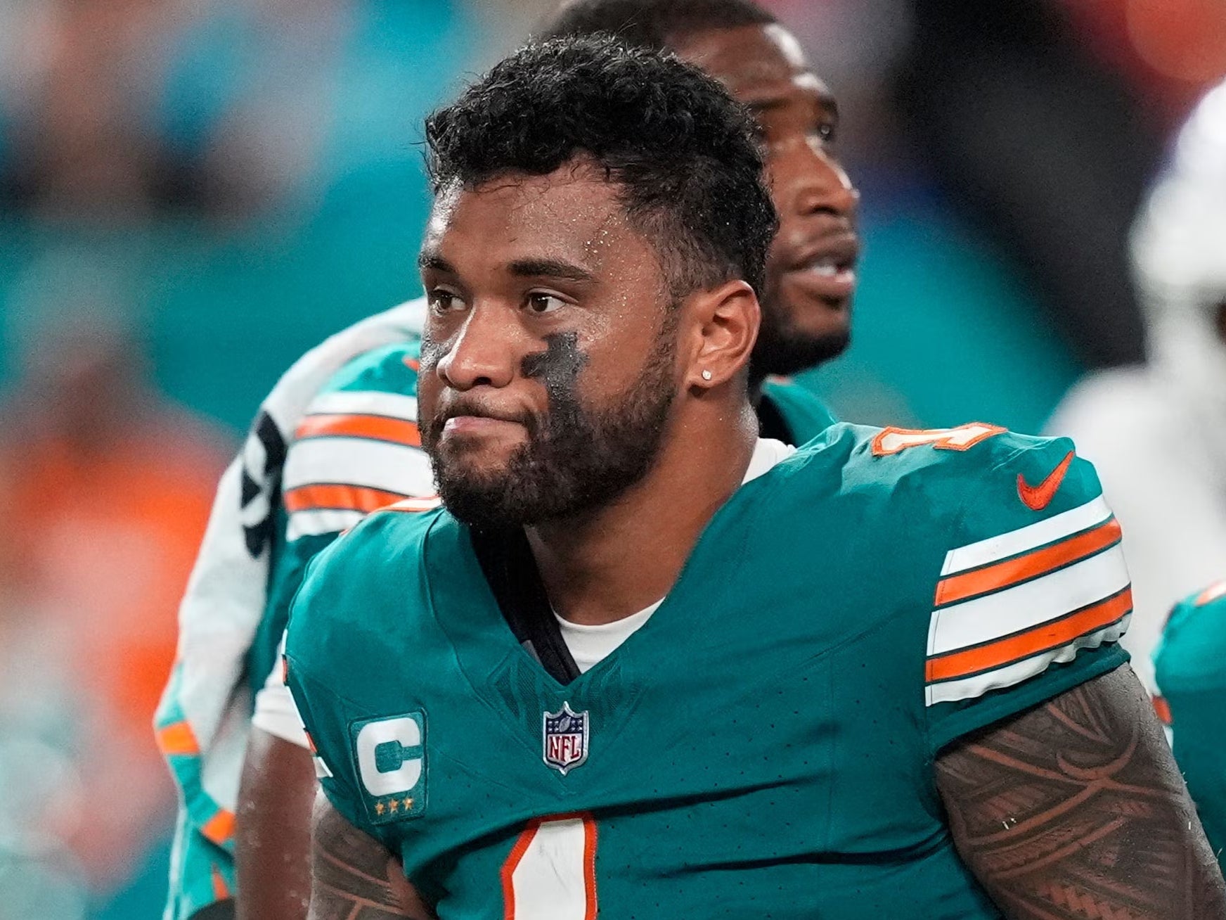 Miami Dolphins head coach Mike McDaniel talks to quarterback Tua Tagovailoa as he leaves the game after suffering a concussion (Rebecca Blackwell/AP)