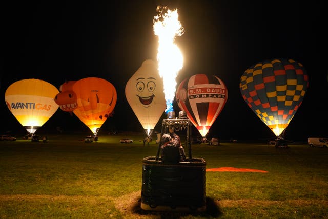 Hot air balloons take part in a night glow during a preview for Icons of the Sky at the Longleat estate in Wiltshire (Andrew Matthews/PA)