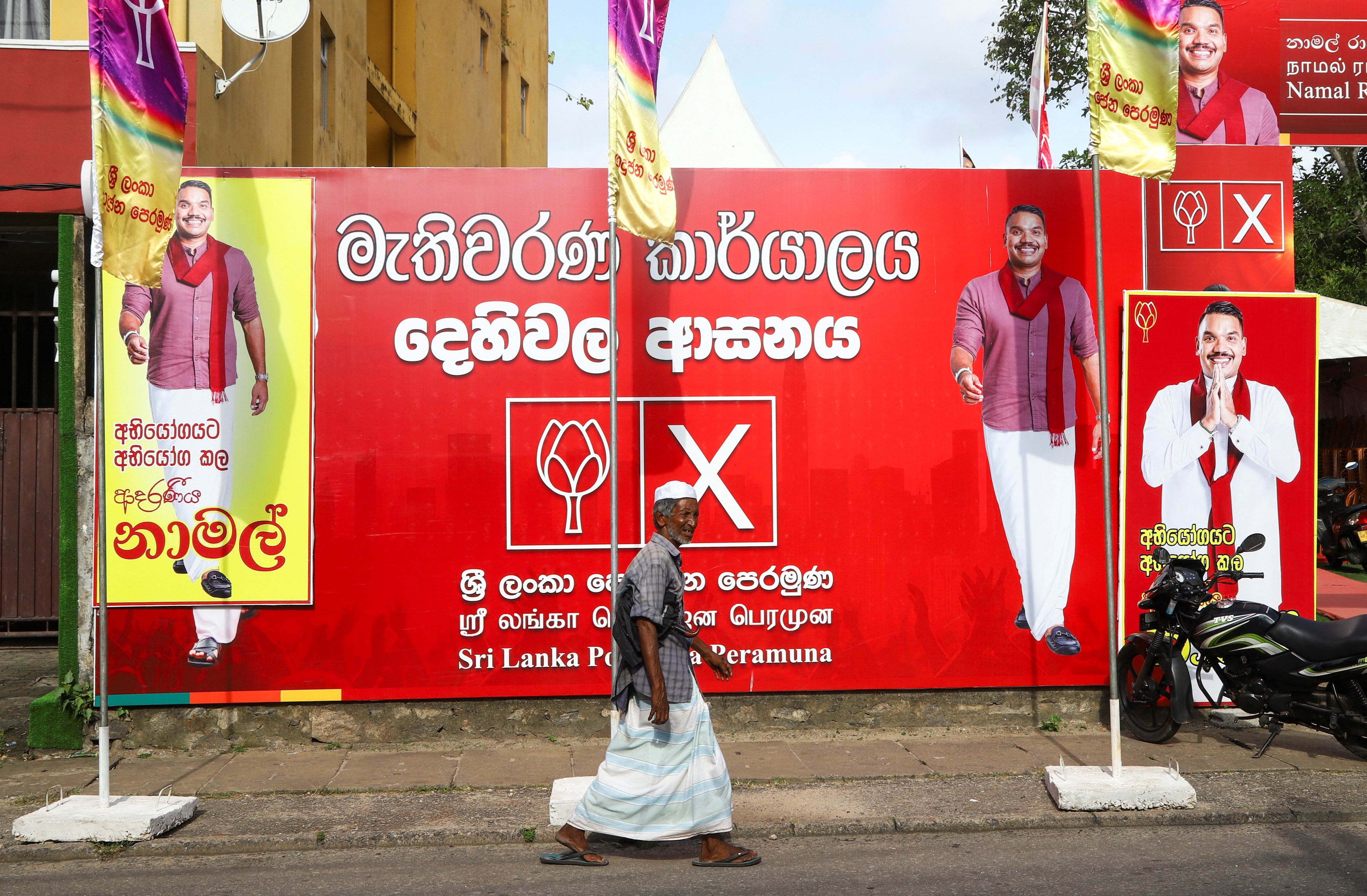 A man walks past an election banner of presidential candidate Namal Rajapaksa outside the Sri Lanka Podujana Peramuna (SLPP) party office