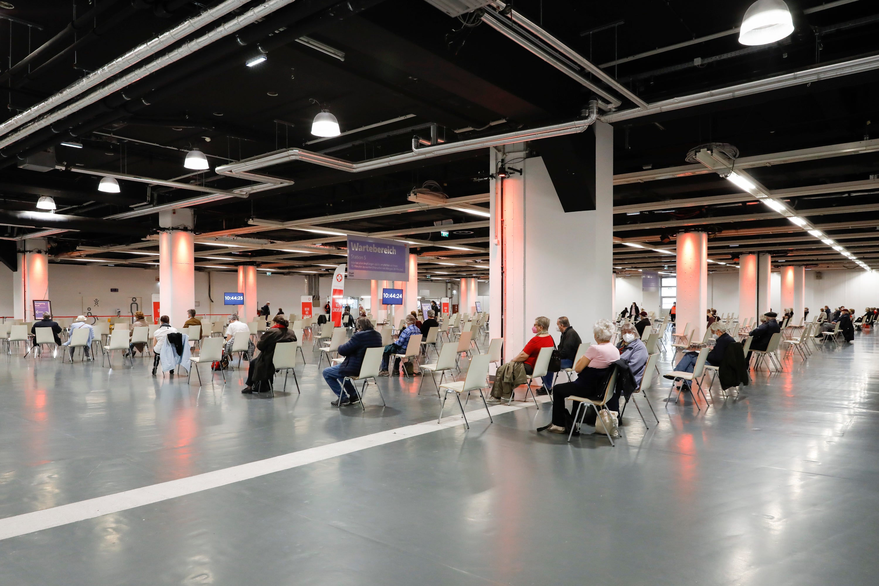 People rest after receiving the vaccination against the new coronavirus in the 'Austria Center Vienna' in Vienna, Austria, Friday, April 9, 2021