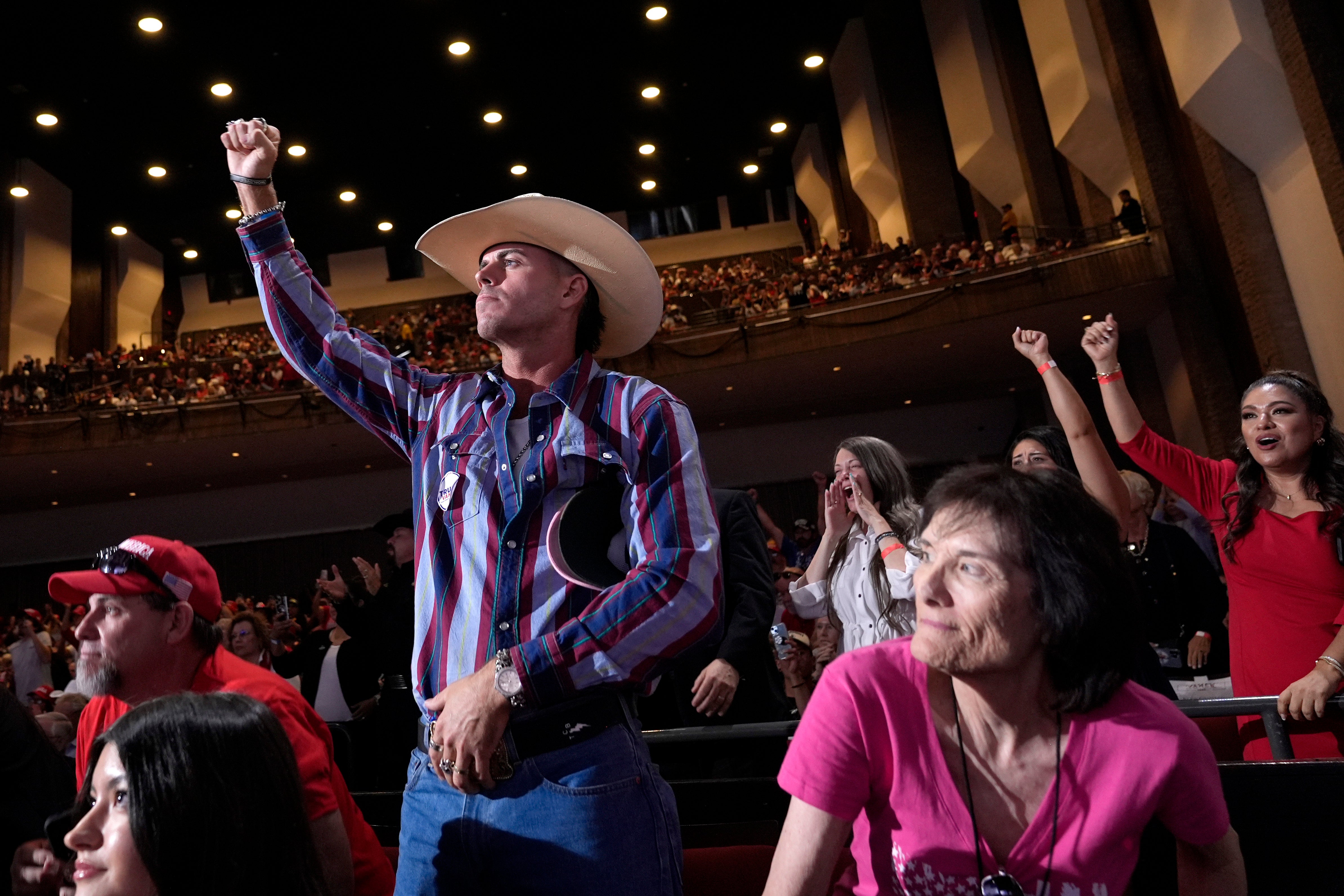 Trump supporters raise fists during the rally in Tucson last week. Some attendees have since complained about suffering eye burning symptoms