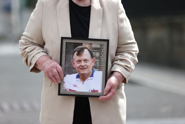 Bridie Brown, the widow of murdered GAA official Sean Brown, holds a picture of him outside the Royal Courts of Justice in Belfast. June 2023 (PA)