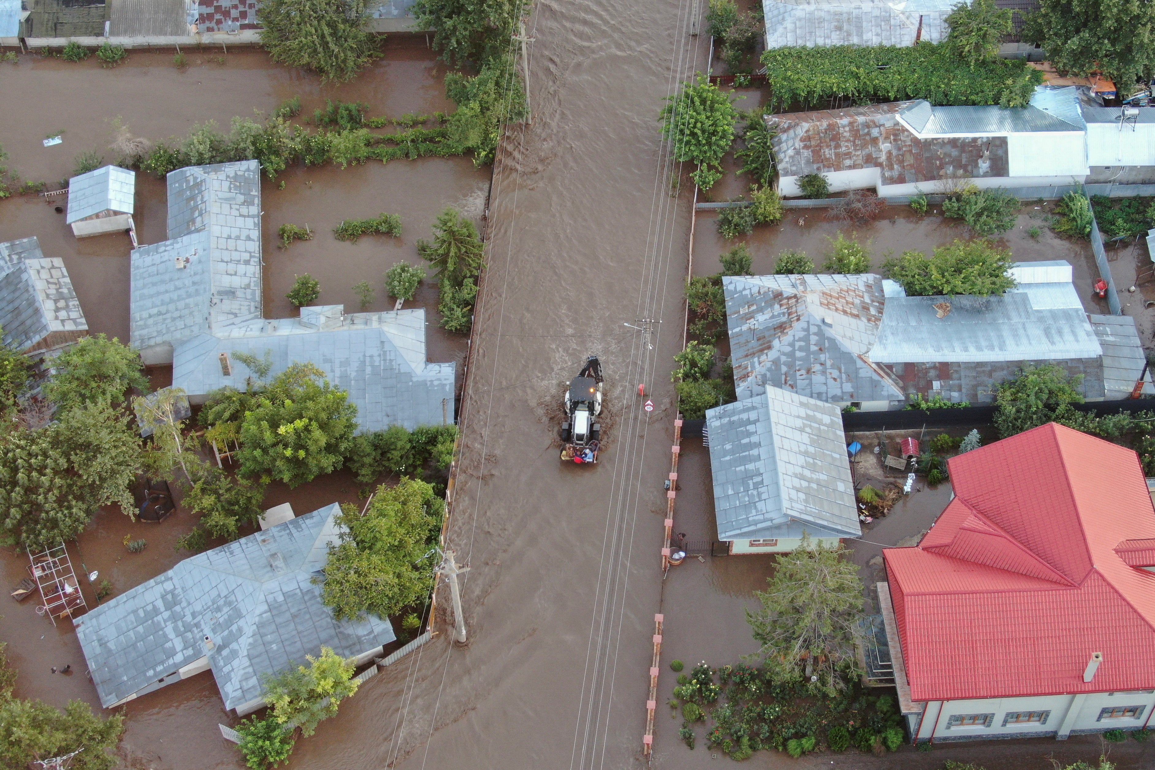 A drone view shows a tractor driving down a flooded road, after heavy rain triggered flooding in Slobozia Conachi, Galati country, Romania