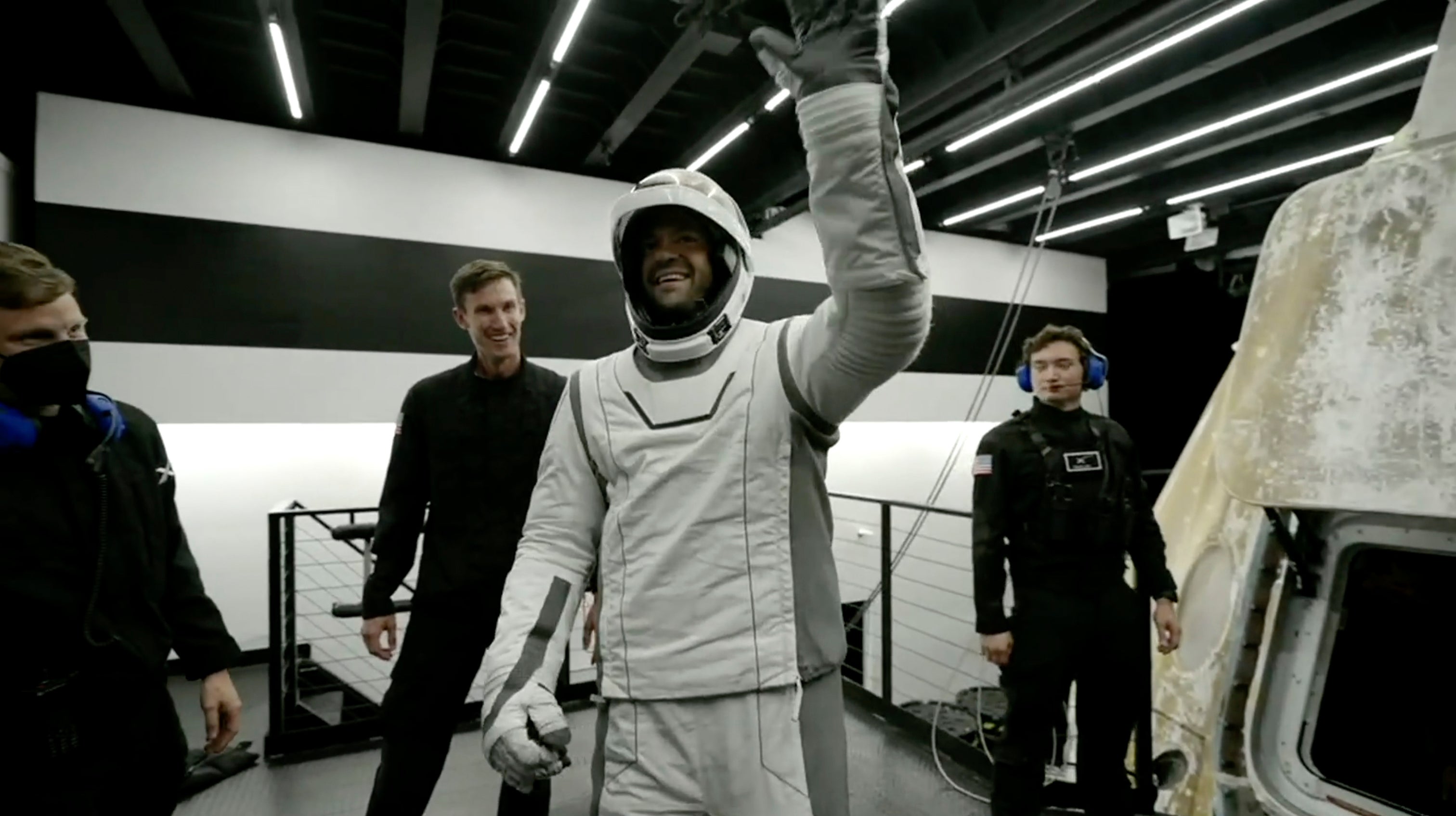 Tech entrepreneur Jared Isaacman, centre, reacts as he gets out of the capsule upon its return to Earth