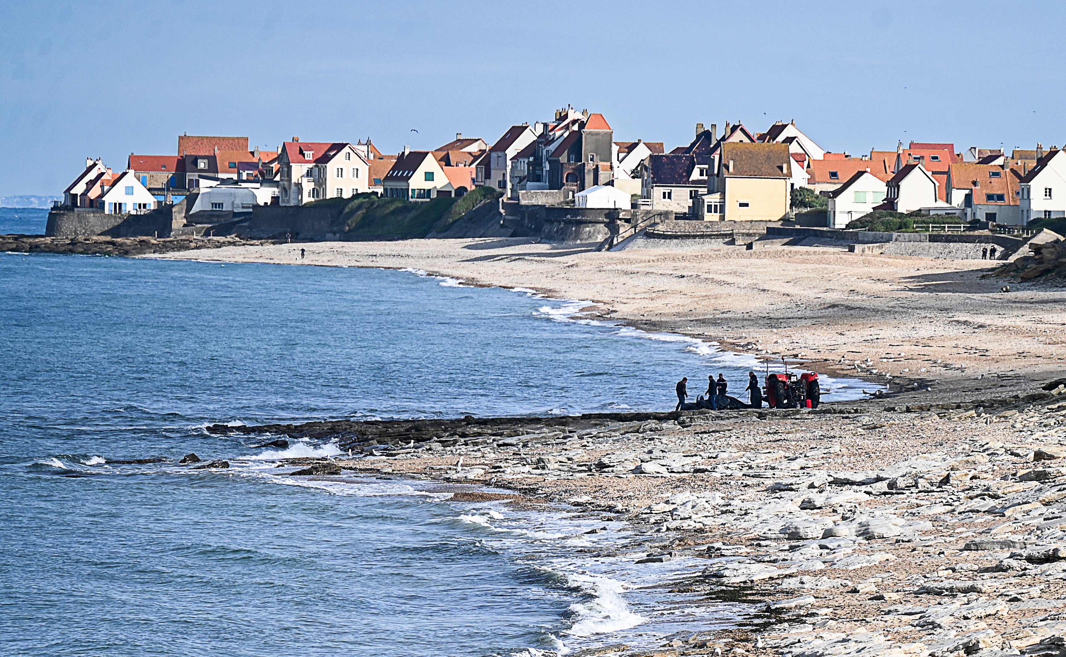 French gendarmes use a tractor to pull the damaged migrants’ boat near the beach of Ambleteuse, northern France