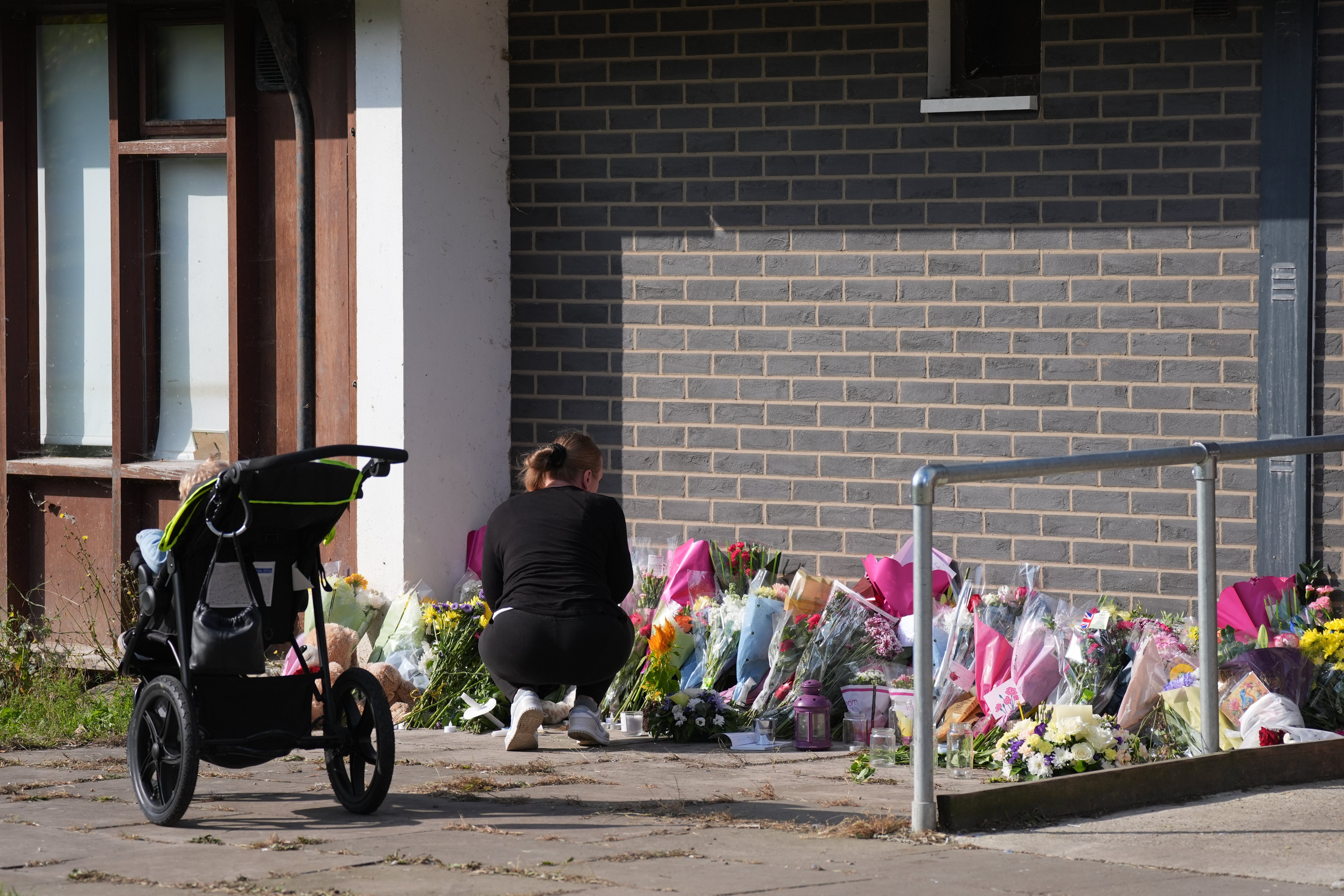 A person lays flowers near the scene