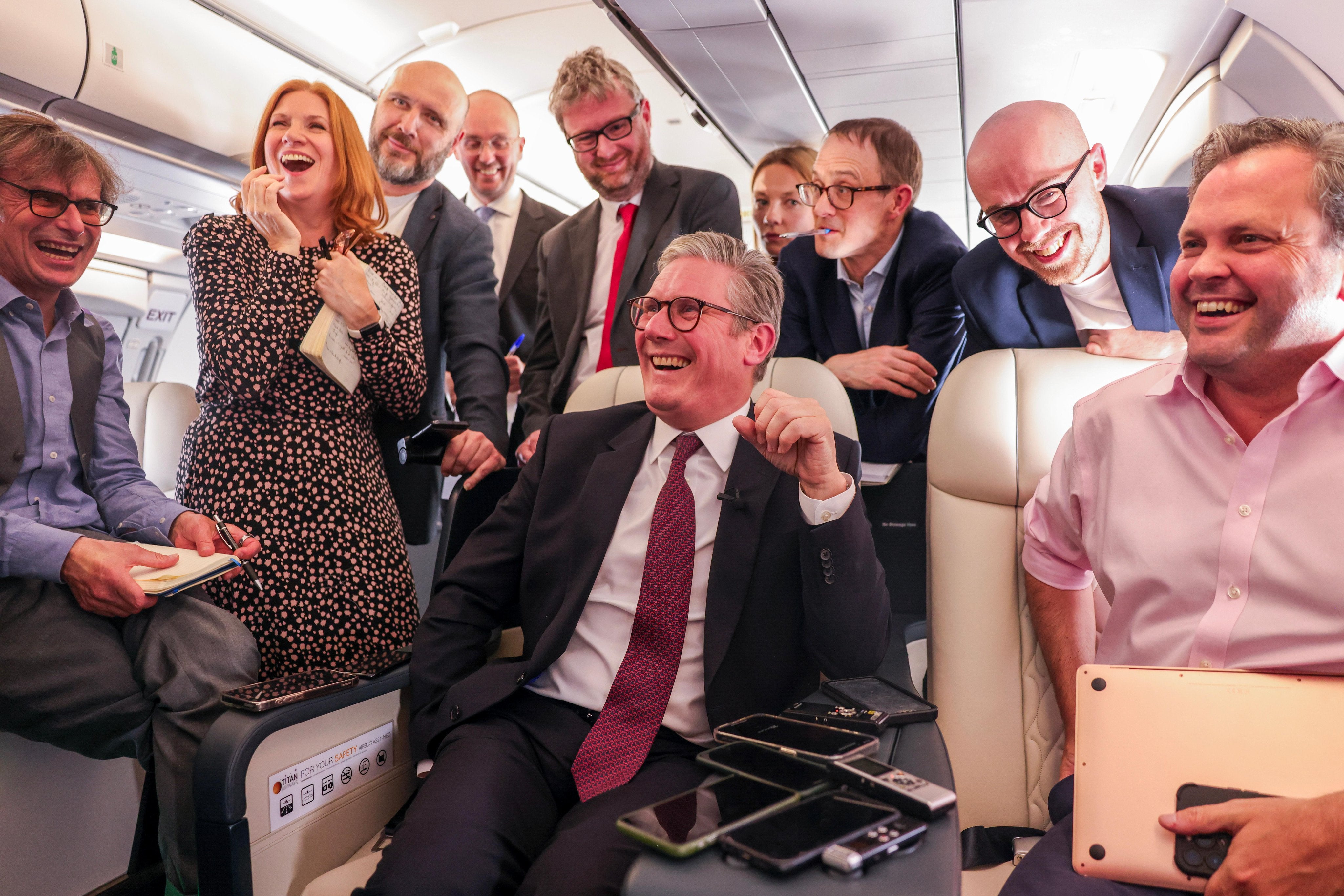 Starmer laughs with journalists at a question during his flight to Washington