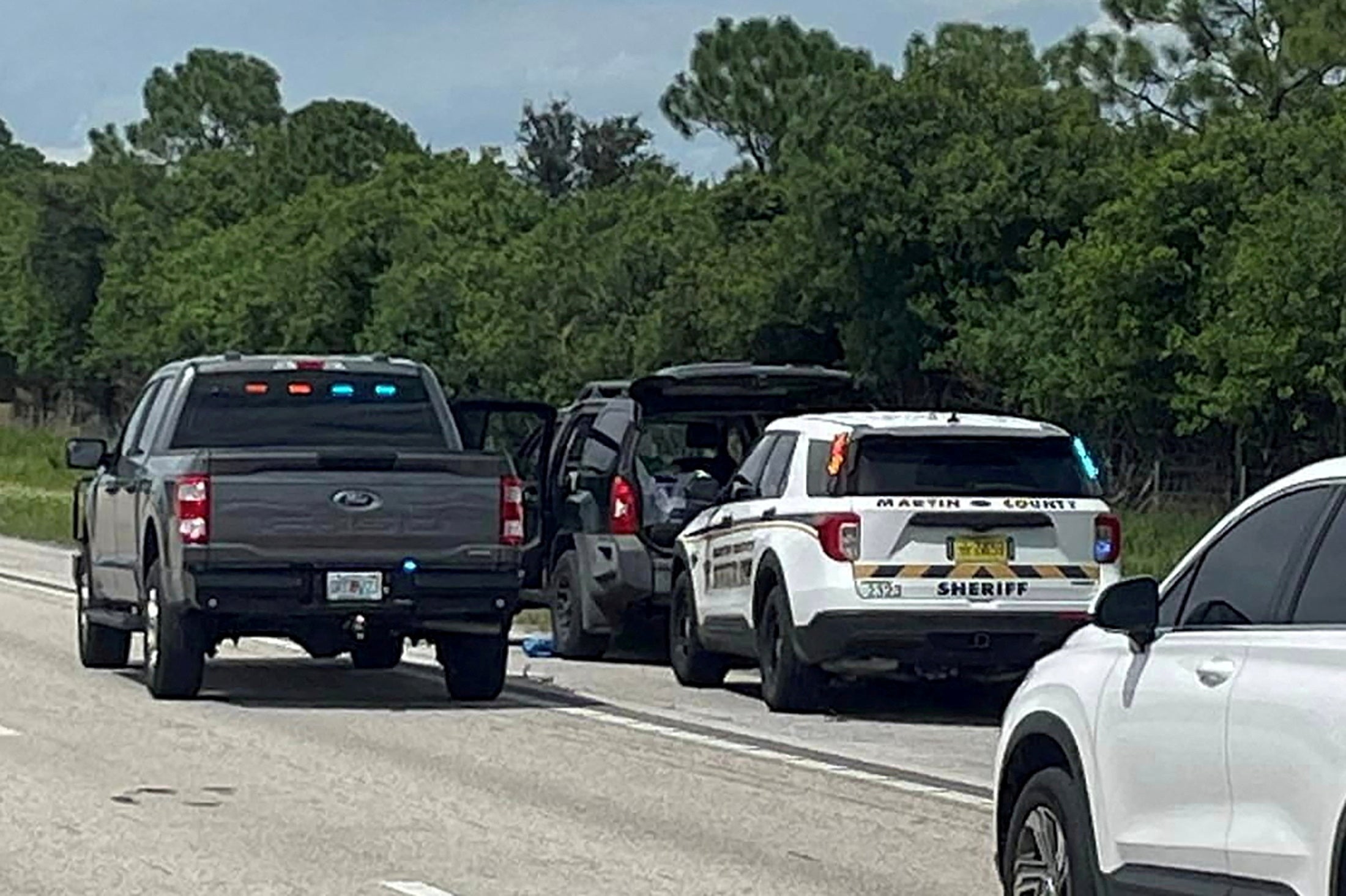 Police vehicles stop a car, following reports of multiple shots fired near the golf course of Republican presidential candidate Donald Trump