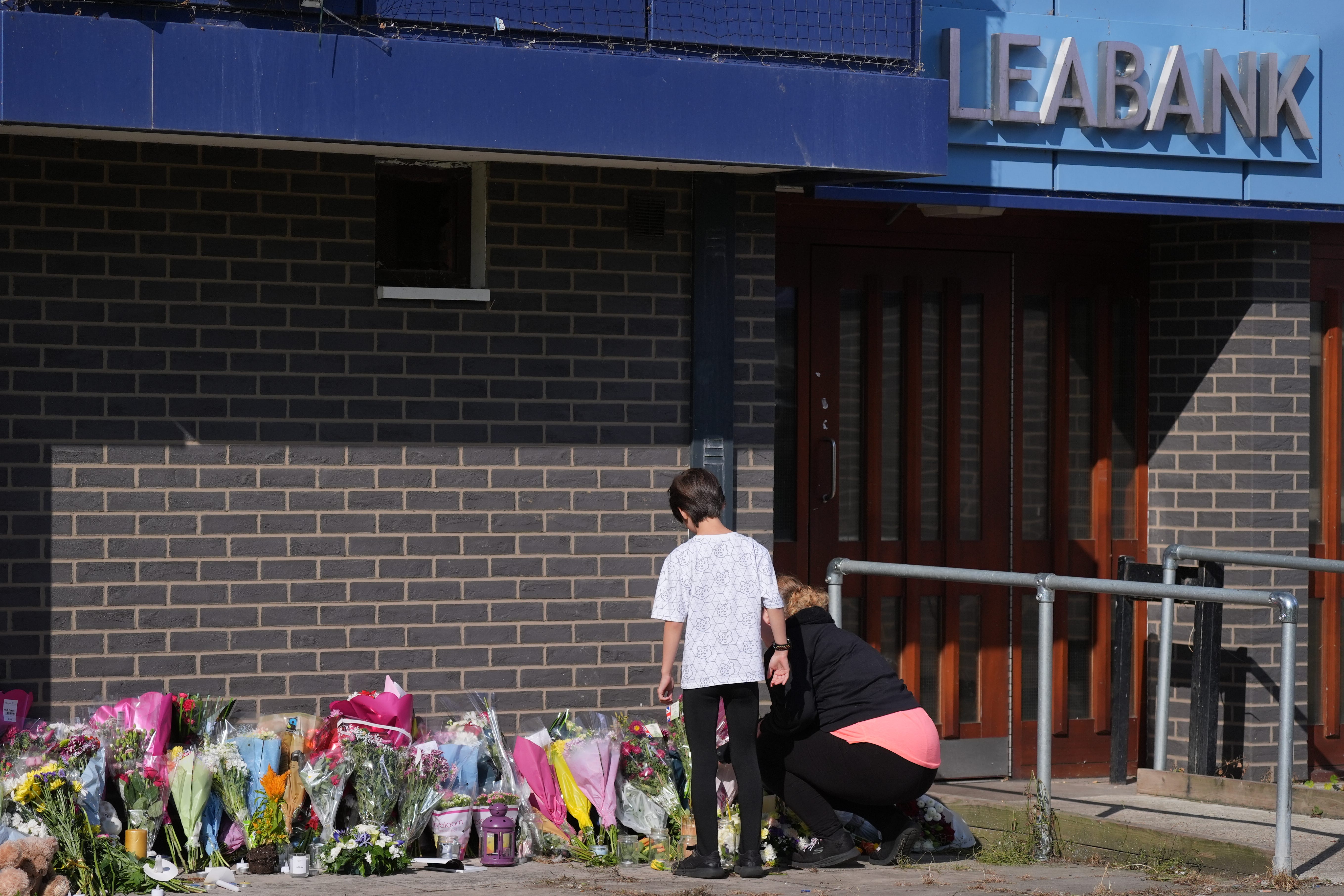 A person lays flowers at Leabank, Luton (PA)