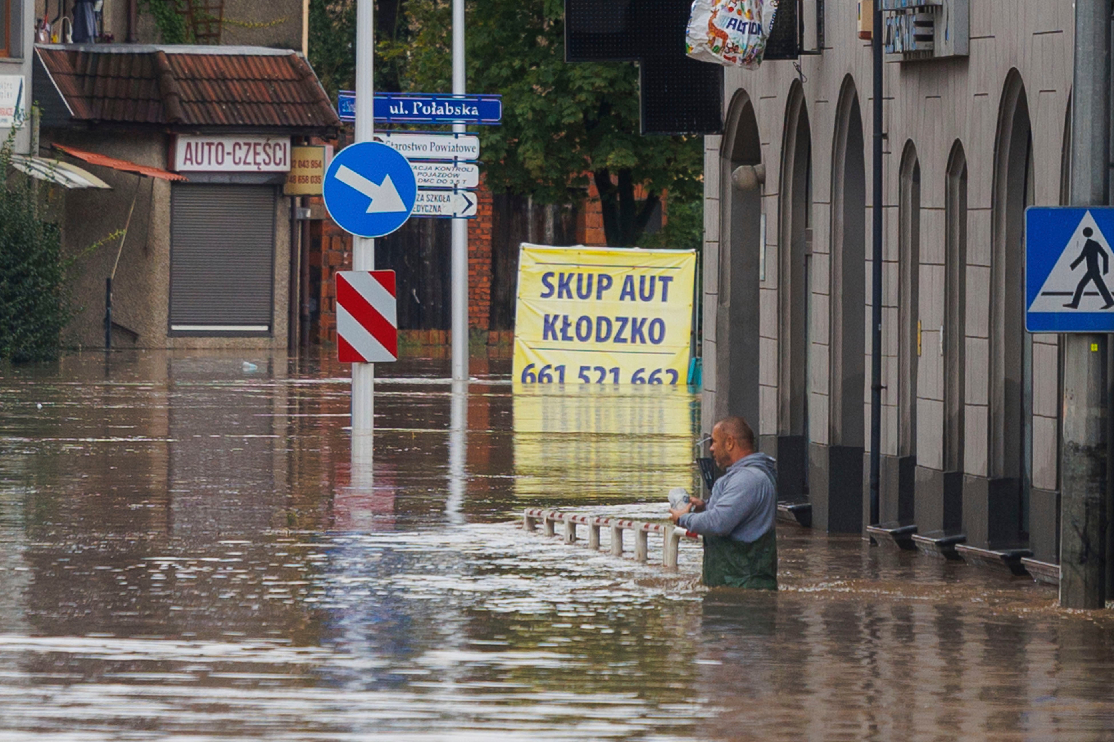 A man stands in waist-deep water that has flooded the streets and houses in the town of Klodzko, in Poland’s southwest