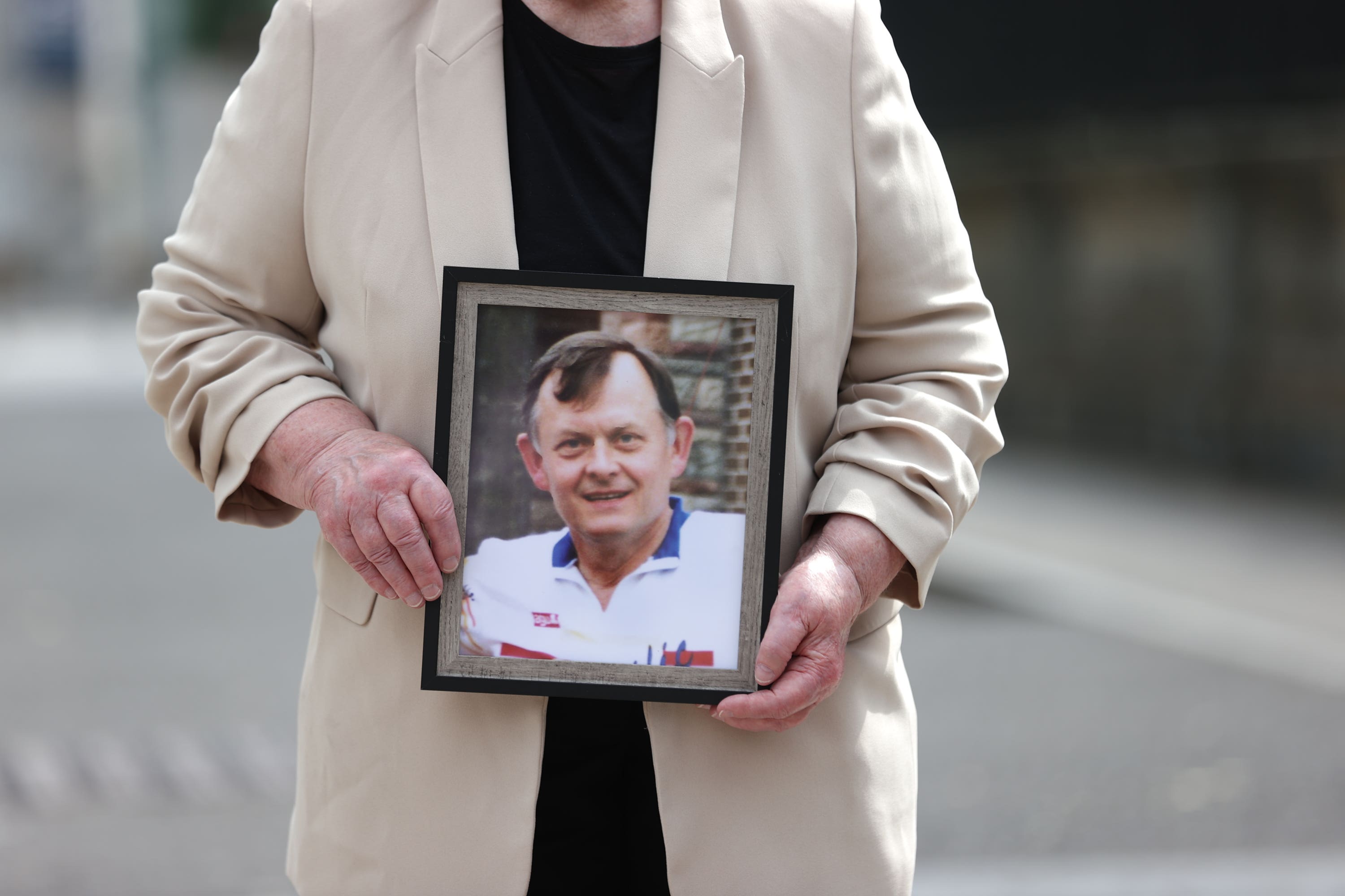 Bridie Brown, the widow of murdered GAA official Sean Brown, holds a picture of him (PA)