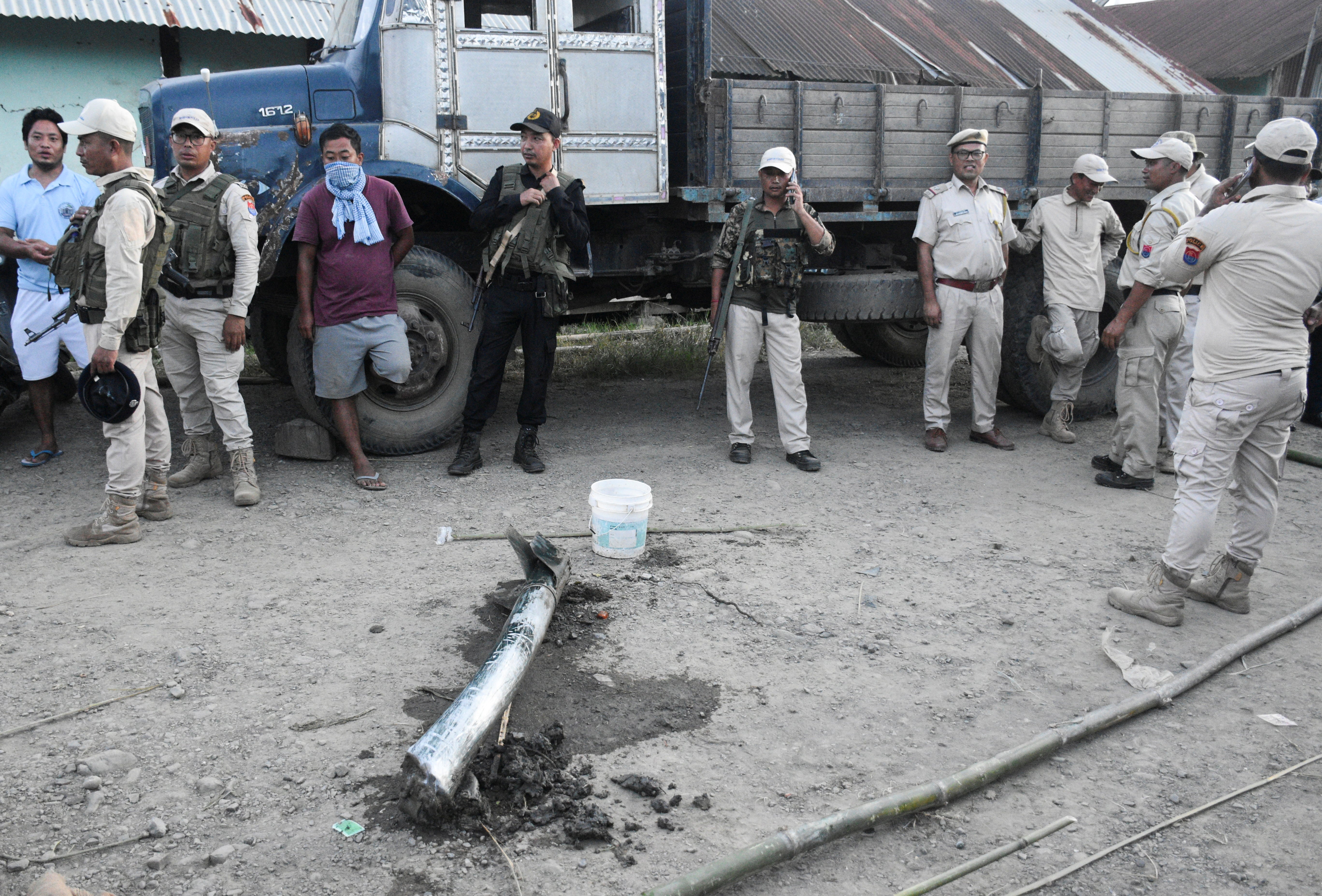 Police personnel and locals stand near the remains of a missile after it struck in Moirang, Manipur, India, 6 September 2024