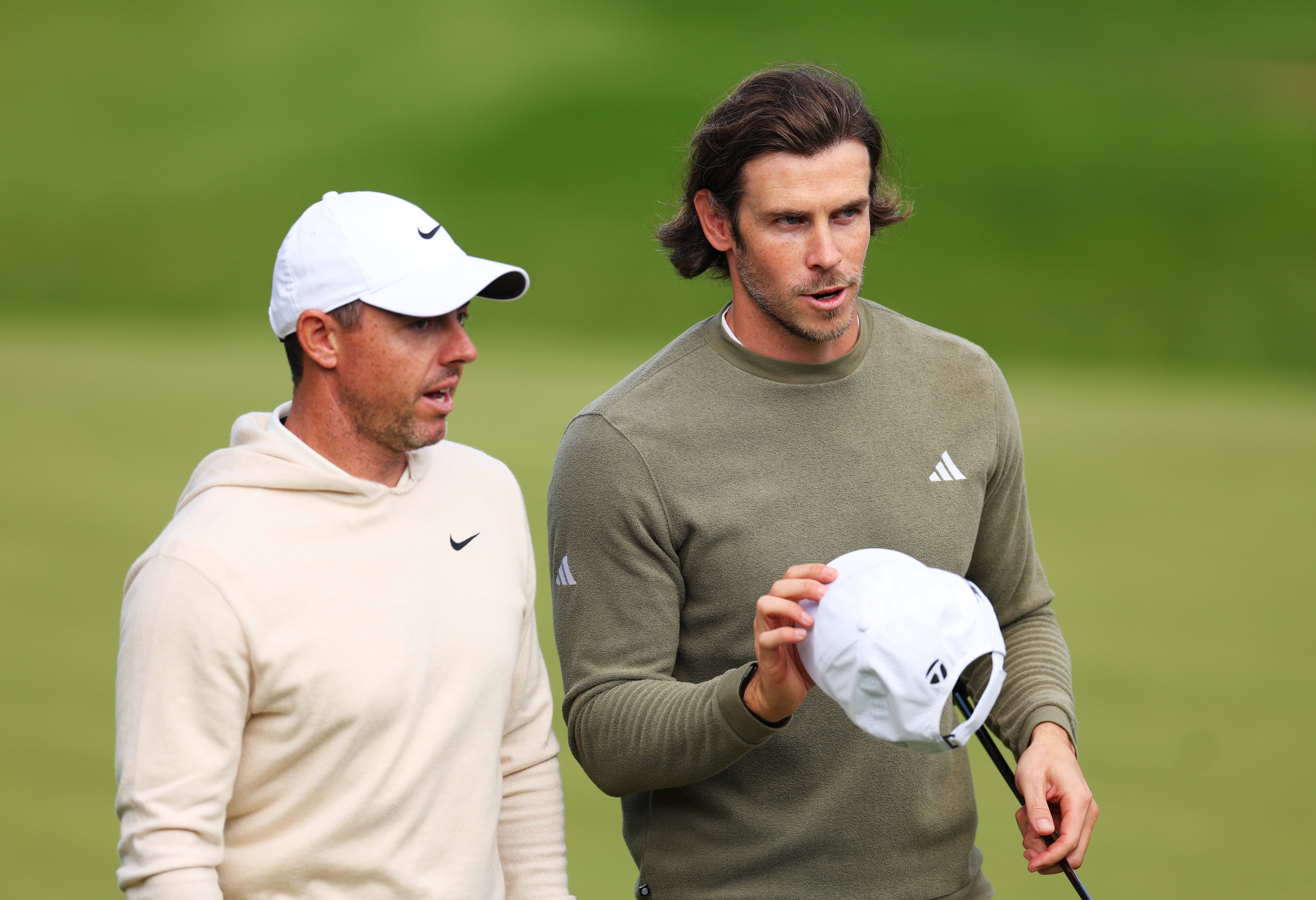 Rory McIlroy of Northern Ireland and Gareth Bale interact