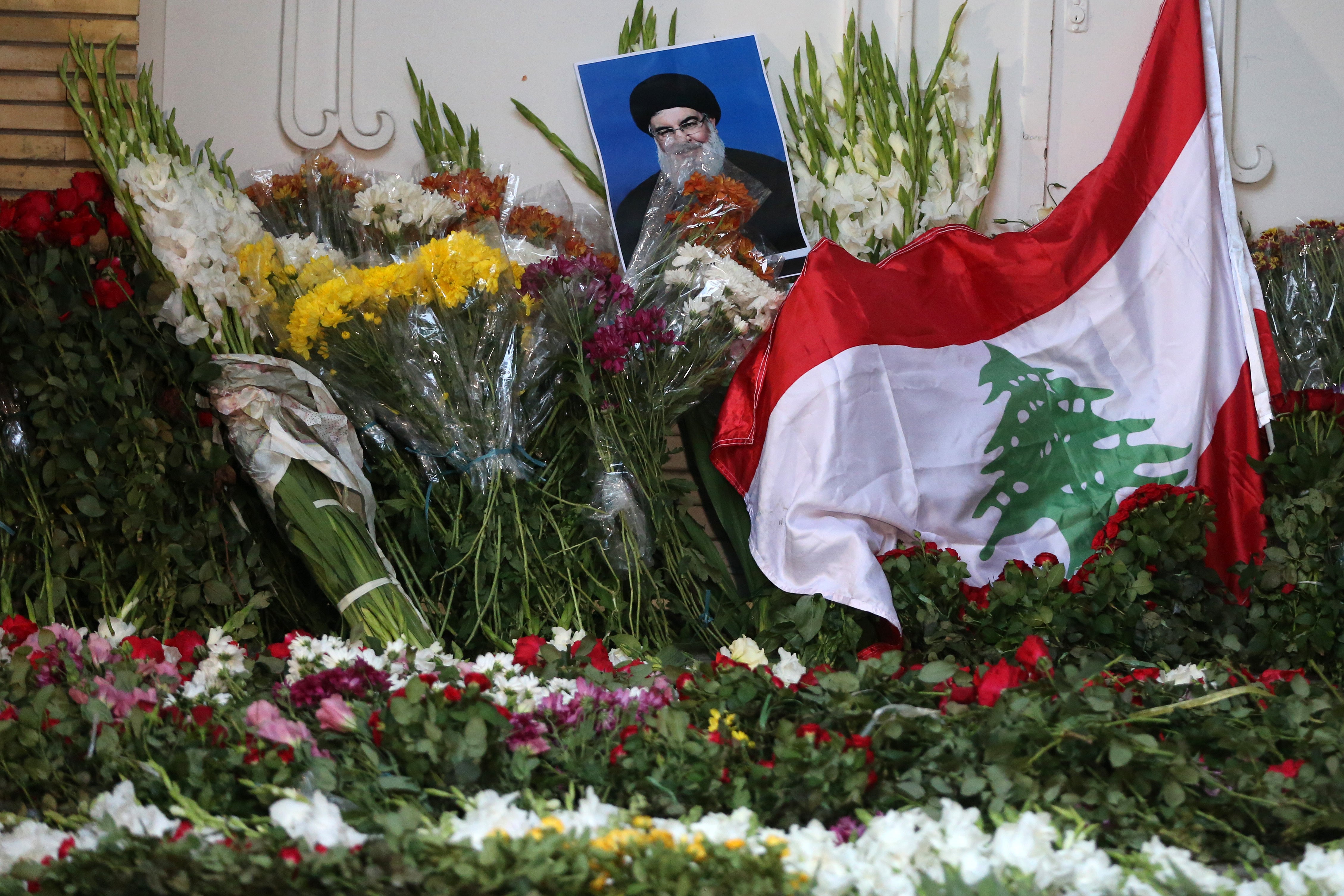 Iranians place carnations and a poster of the child Fatma Abdullah, who was killed in the attacks