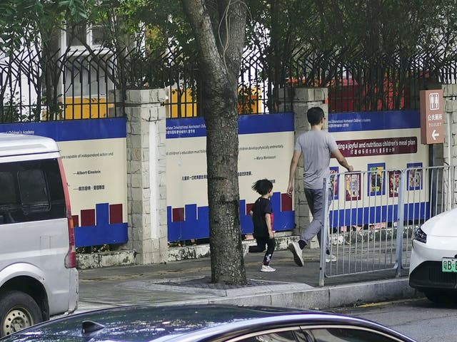 <p>People walk past the Shenzhen Japanese School in Shenzhen, China Wednesday, 18 September 2024, where a 10-year-old Japanese student was stabbed by a man</p>