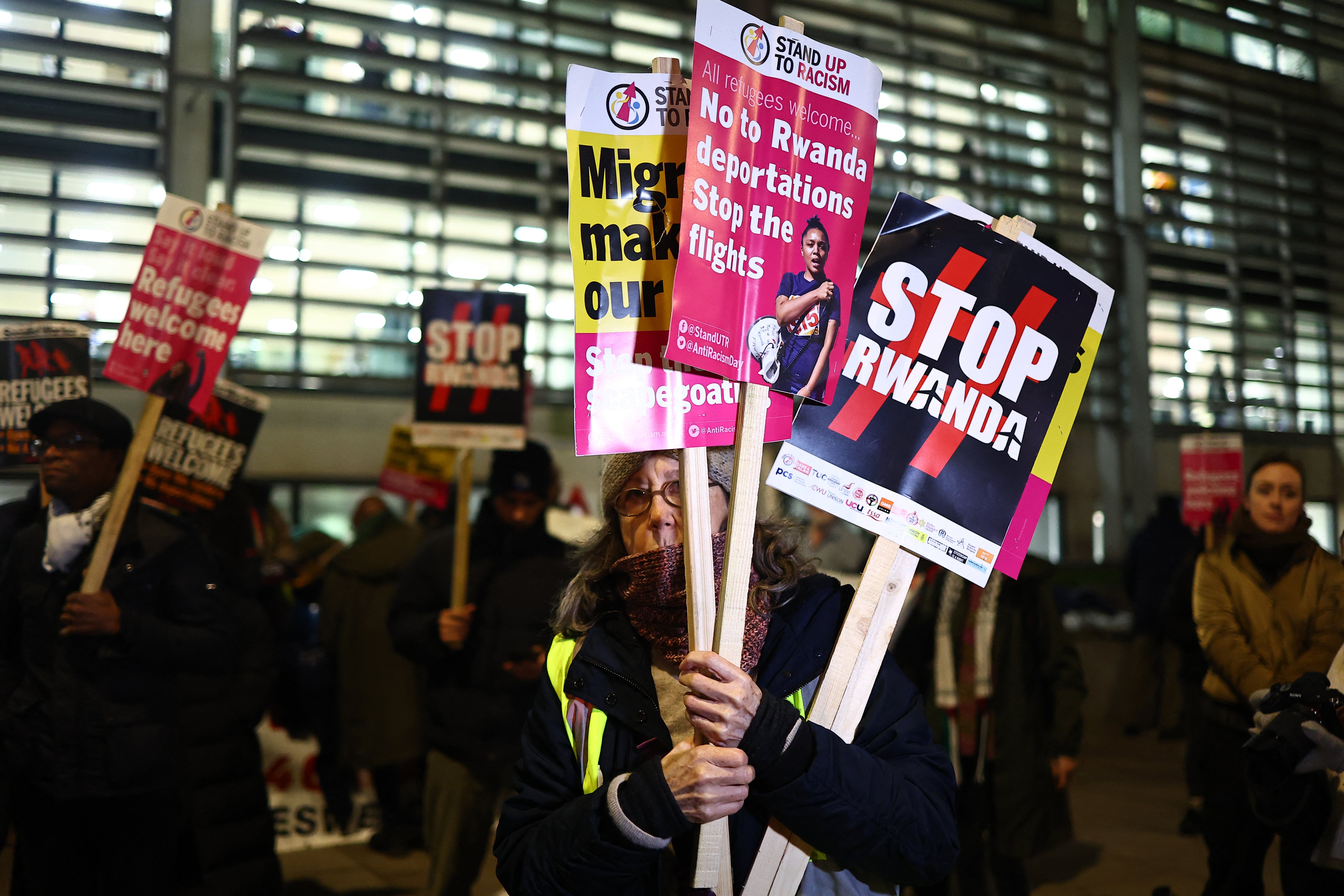 Demonstrators hold placards during a protest against the Tory government's plan to deport immigrants to Rwanda, outside the Home Office.