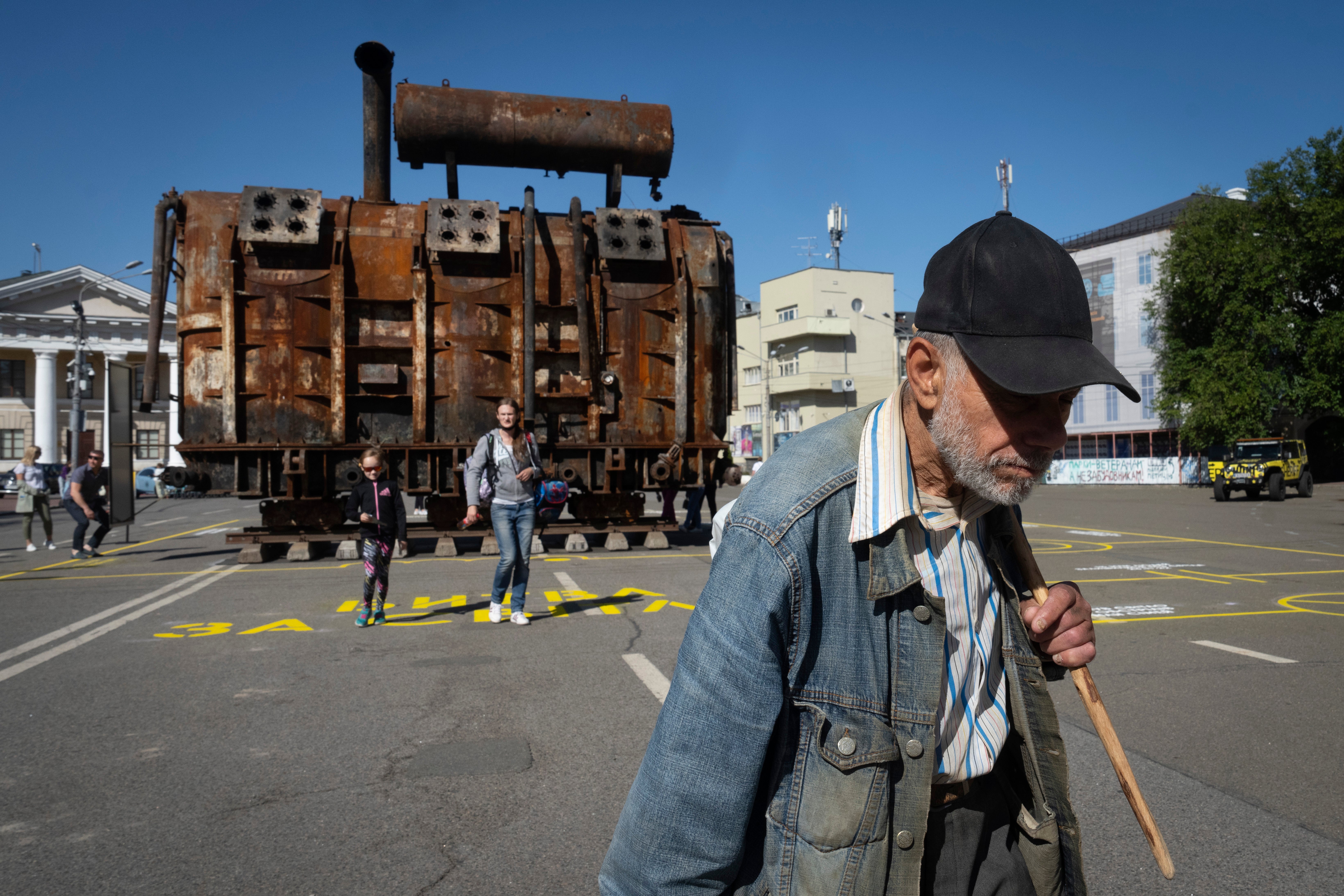 A man passes by a burnt transformer from one of power plants badly damaged in one of Russia's recent missile attacks on energy system in Kyiv,