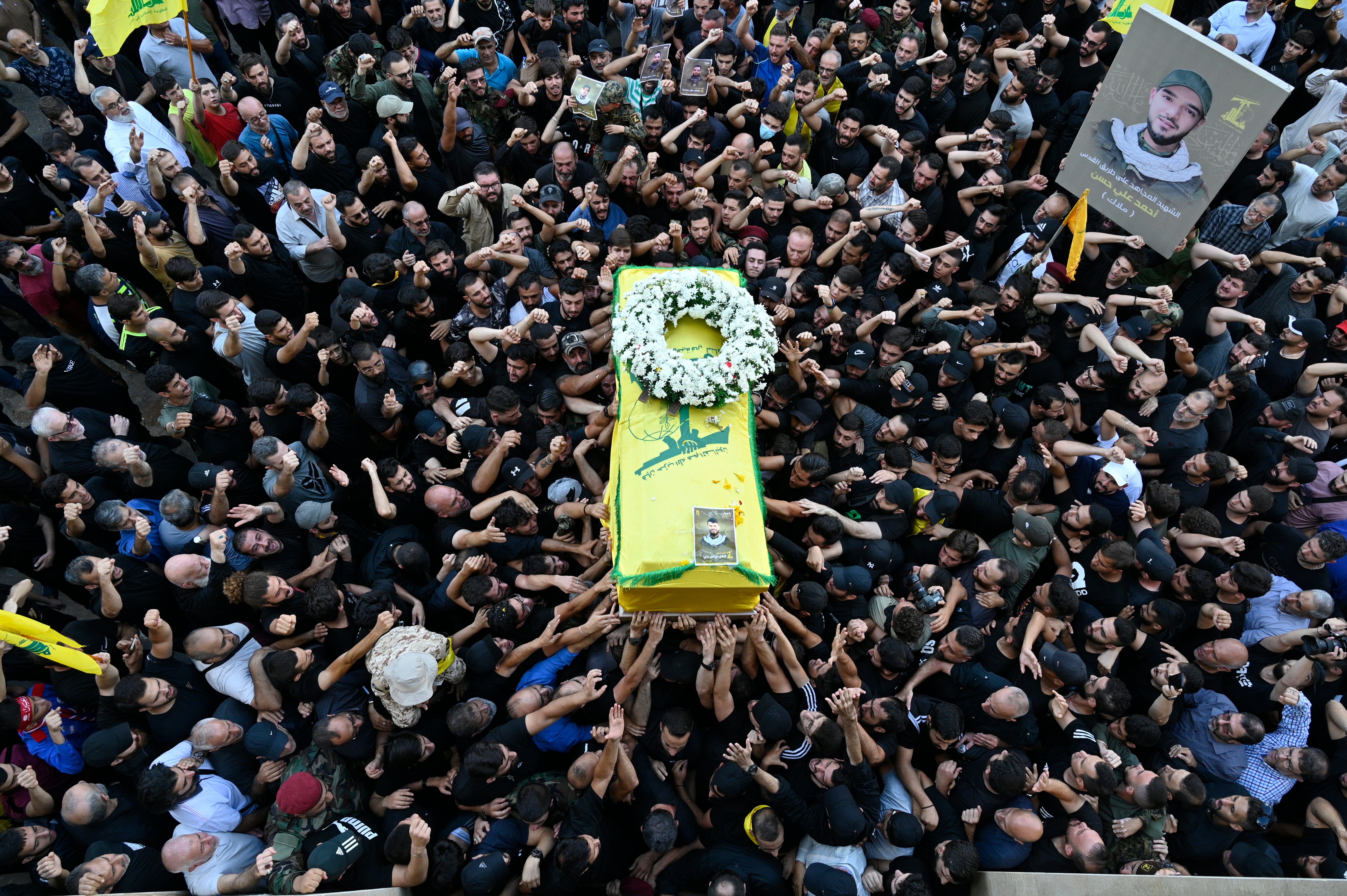 Mourners carry the coffin of one of the people who died the communication devices blasts