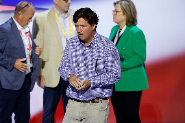 <p>Tucker Carlson holds a pack of nicotine pouches at the Republican National Convention in July</p>