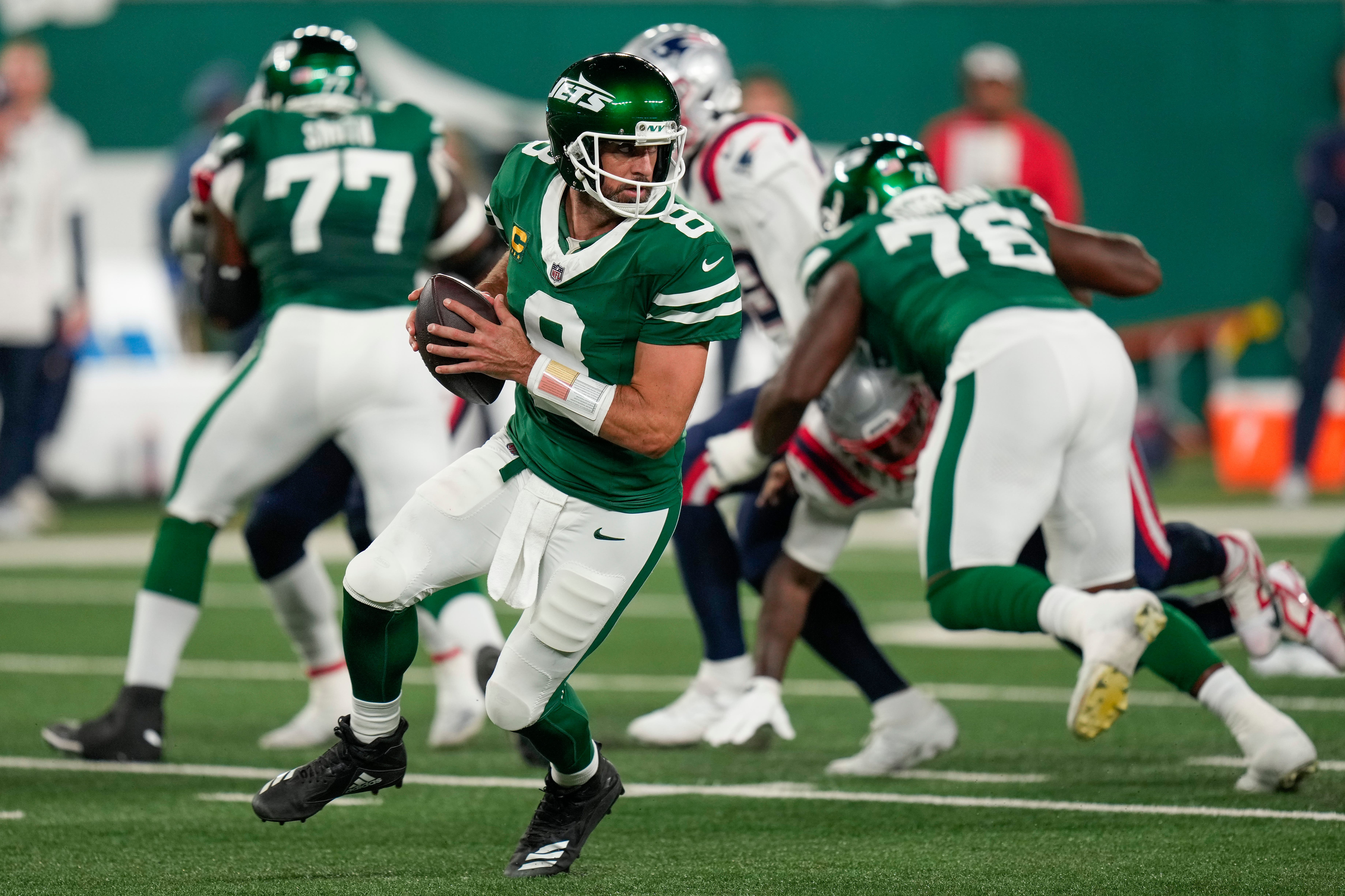 New York Jets quarterback Aaron Rodgers rolls out of the pocket against the New England Patriots (Seth Wenig/AP)