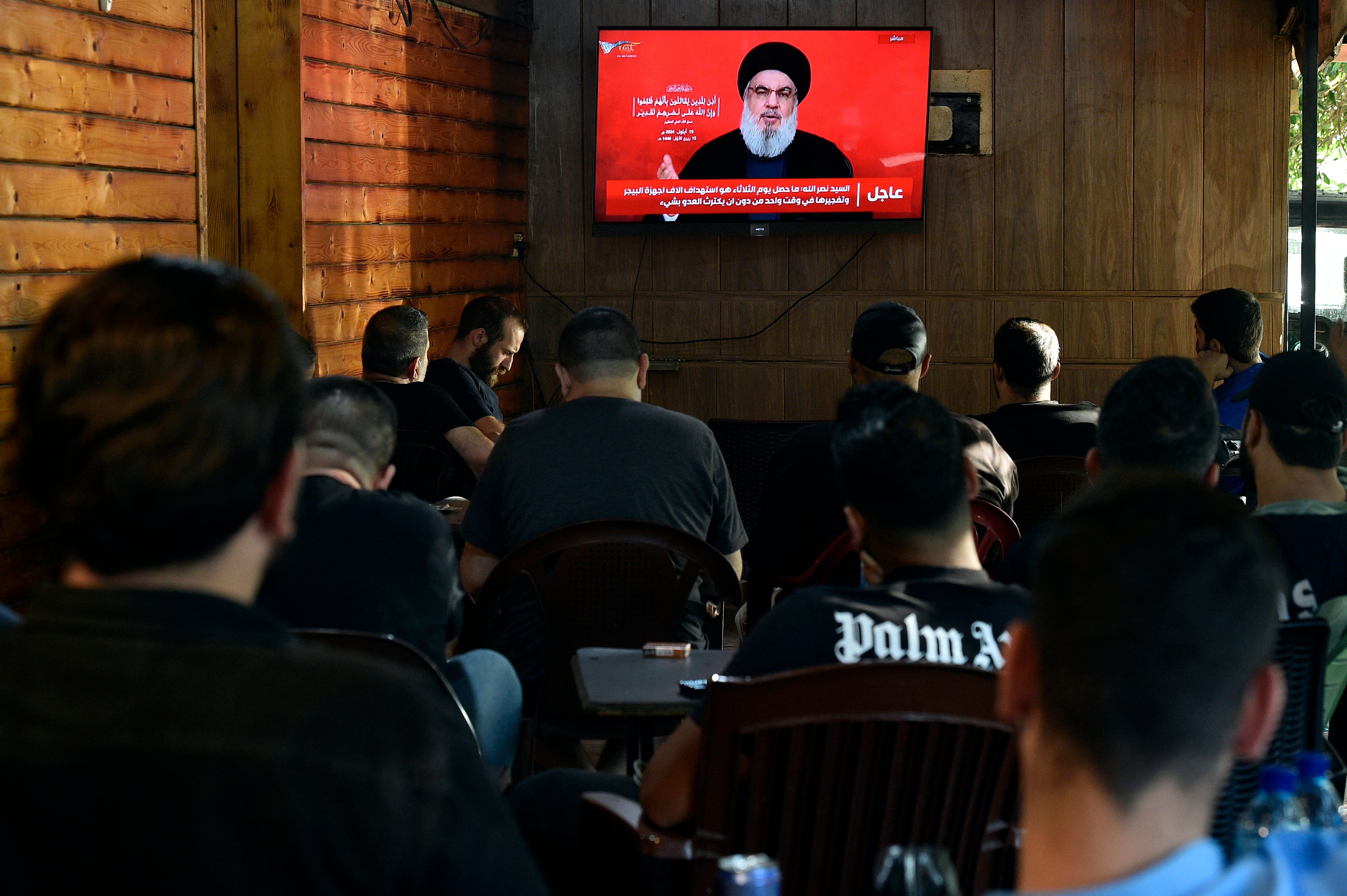 People watch Hezbollah secretary-engeral Hassan Nasrallah delivering a televised speech at a coffee shop in the southern suburb of Beirut, Lebanon, 19 September 2024