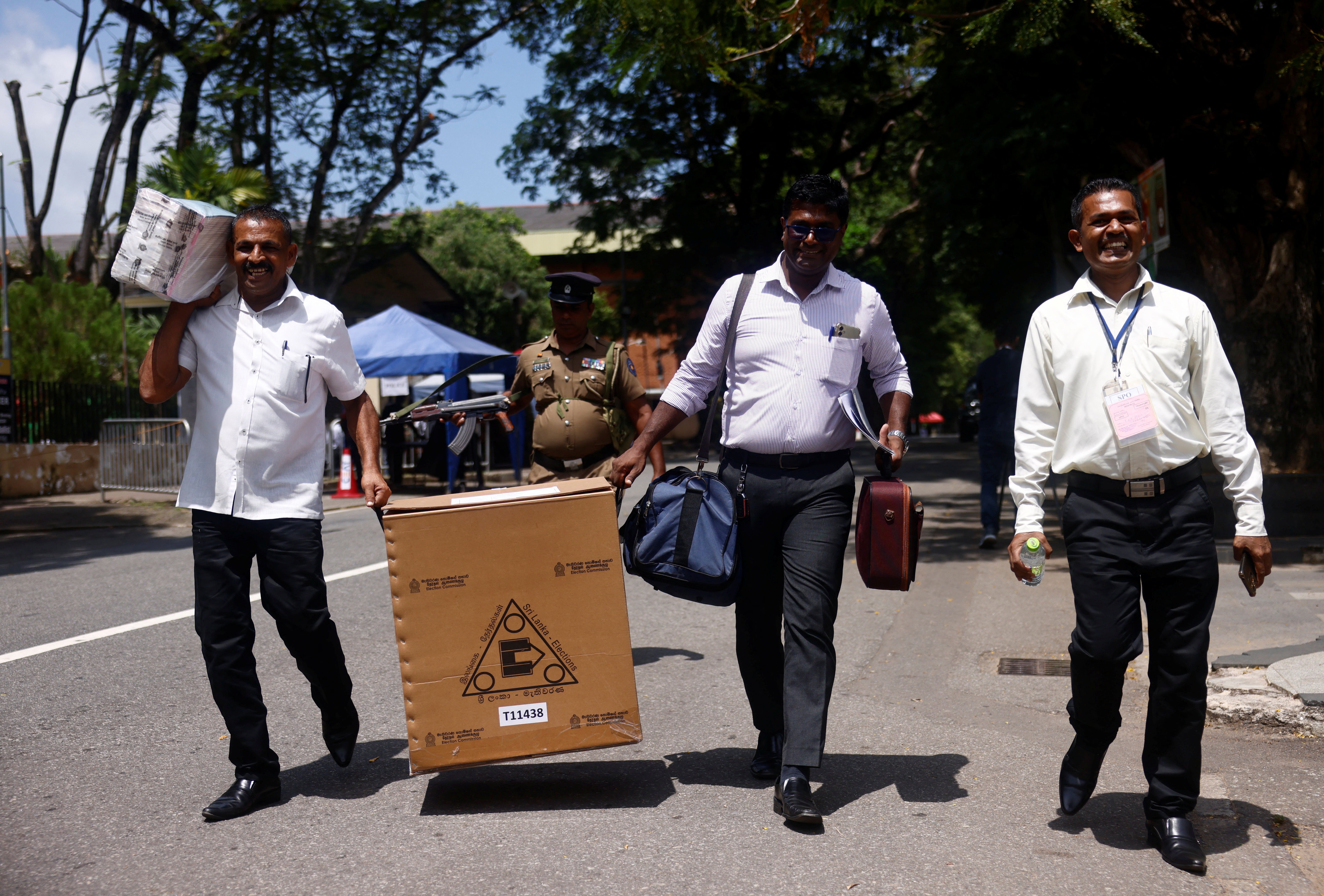 Sri Lankan police and election officials load ballot boxes and papers into busses from a distribution center to polling stations