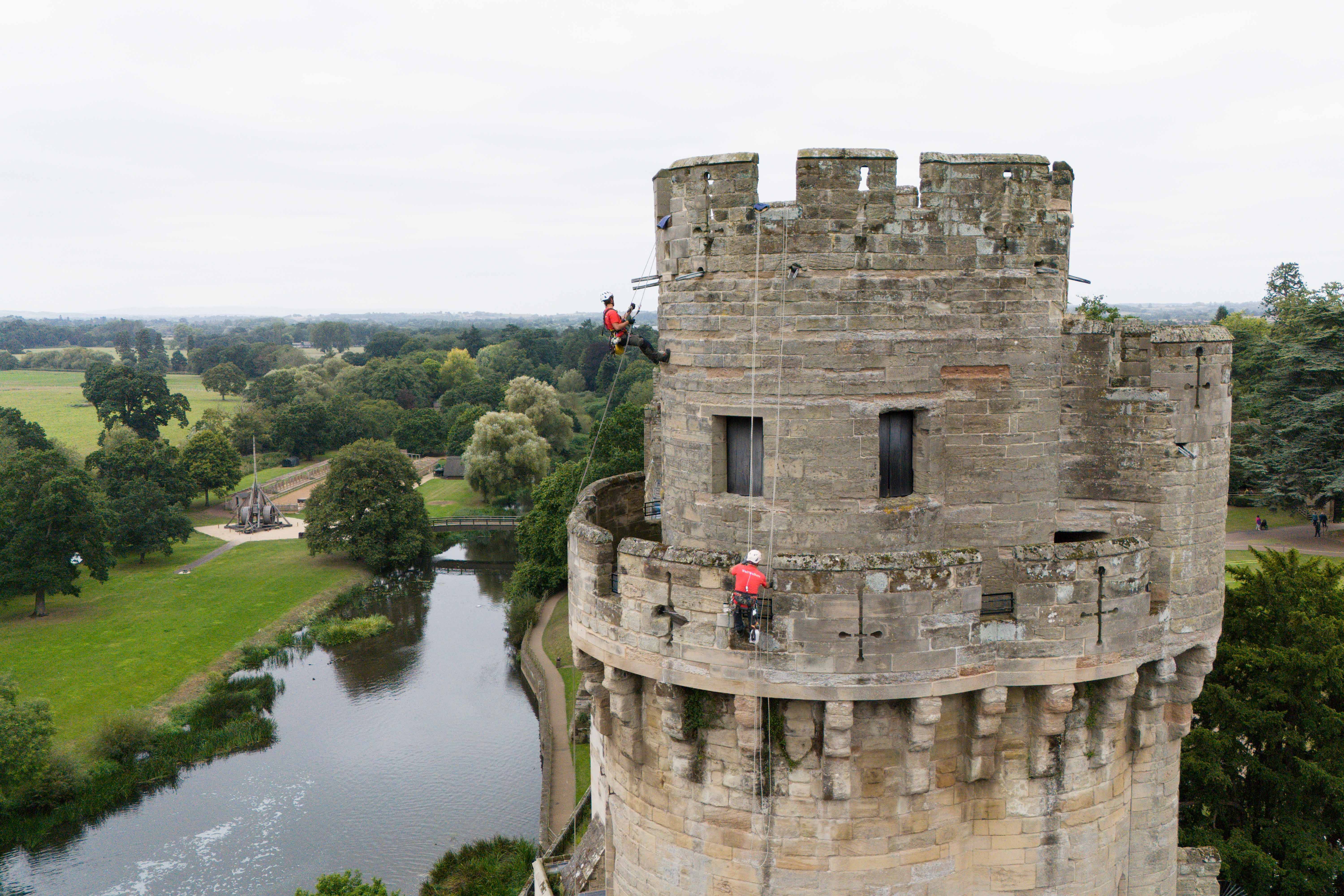 Building restoration specialists abseil down the walls of Warwick Castle’s south front, known as Caesar’s Tower, as they removed weeds and tidied the 800-year-old stonework during the landmark’s annual external clean (Jacob King/PA)