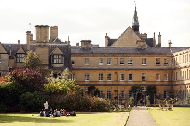 <p>Students relax in the grounds of Trinity College</p>