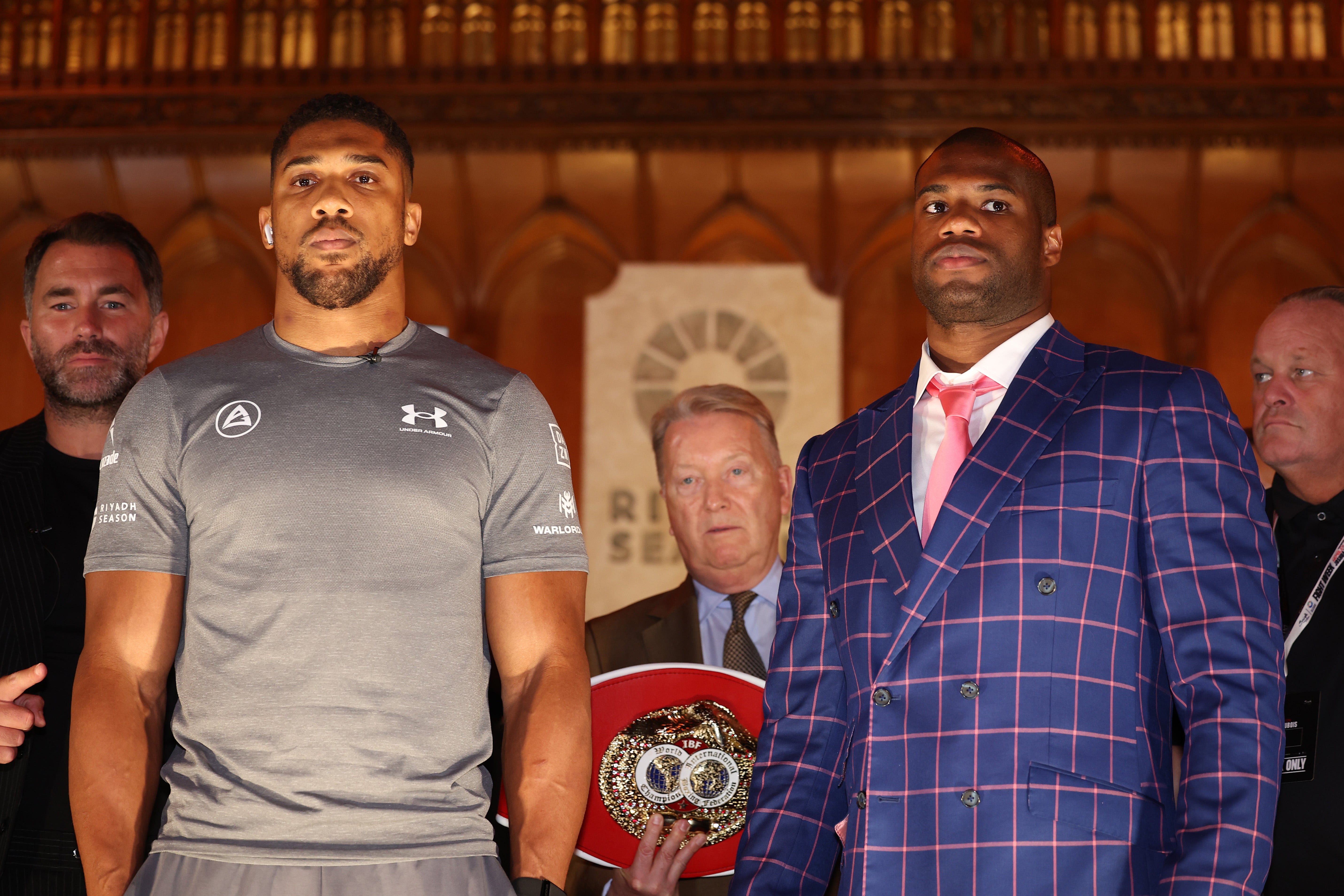 Anthony Joshua and Daniel Dubois react on stage ahead of the IBF Heavyweight title fight