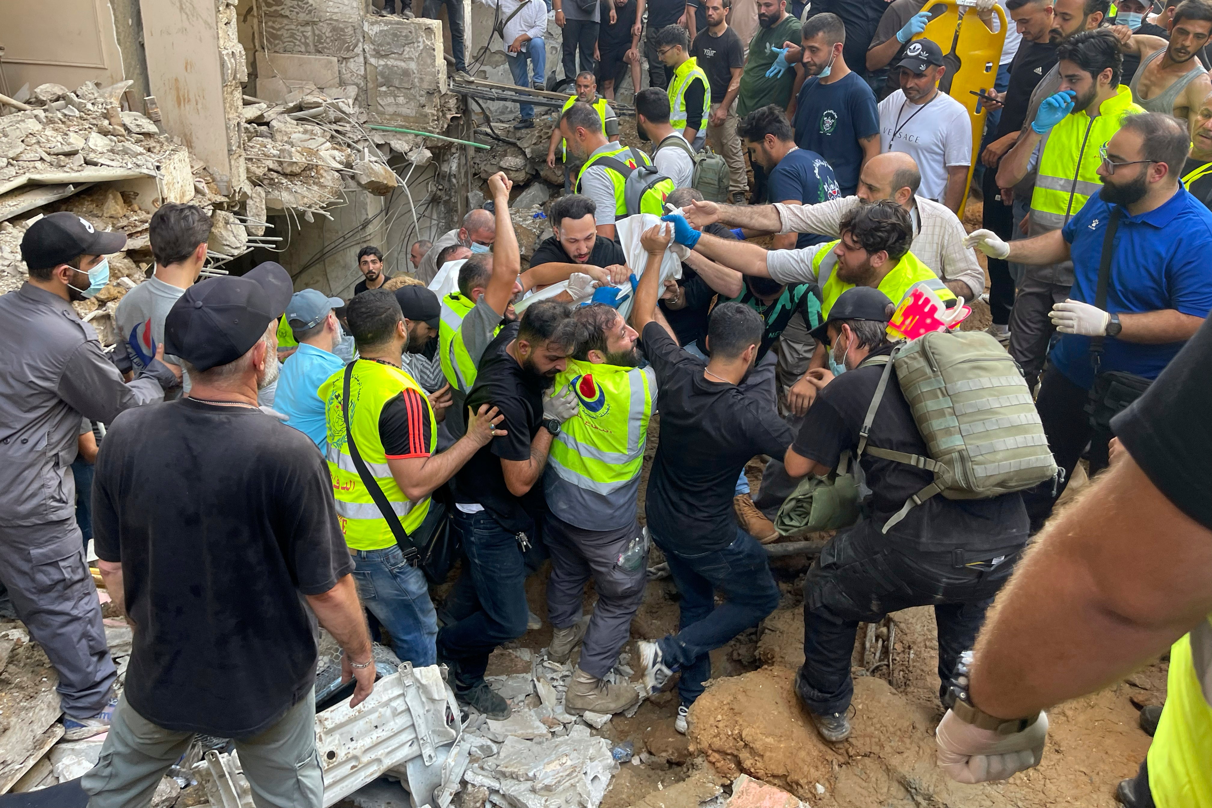 Rescuers carry a body at the scene of a missile strike in the southern suburbs of Beirut