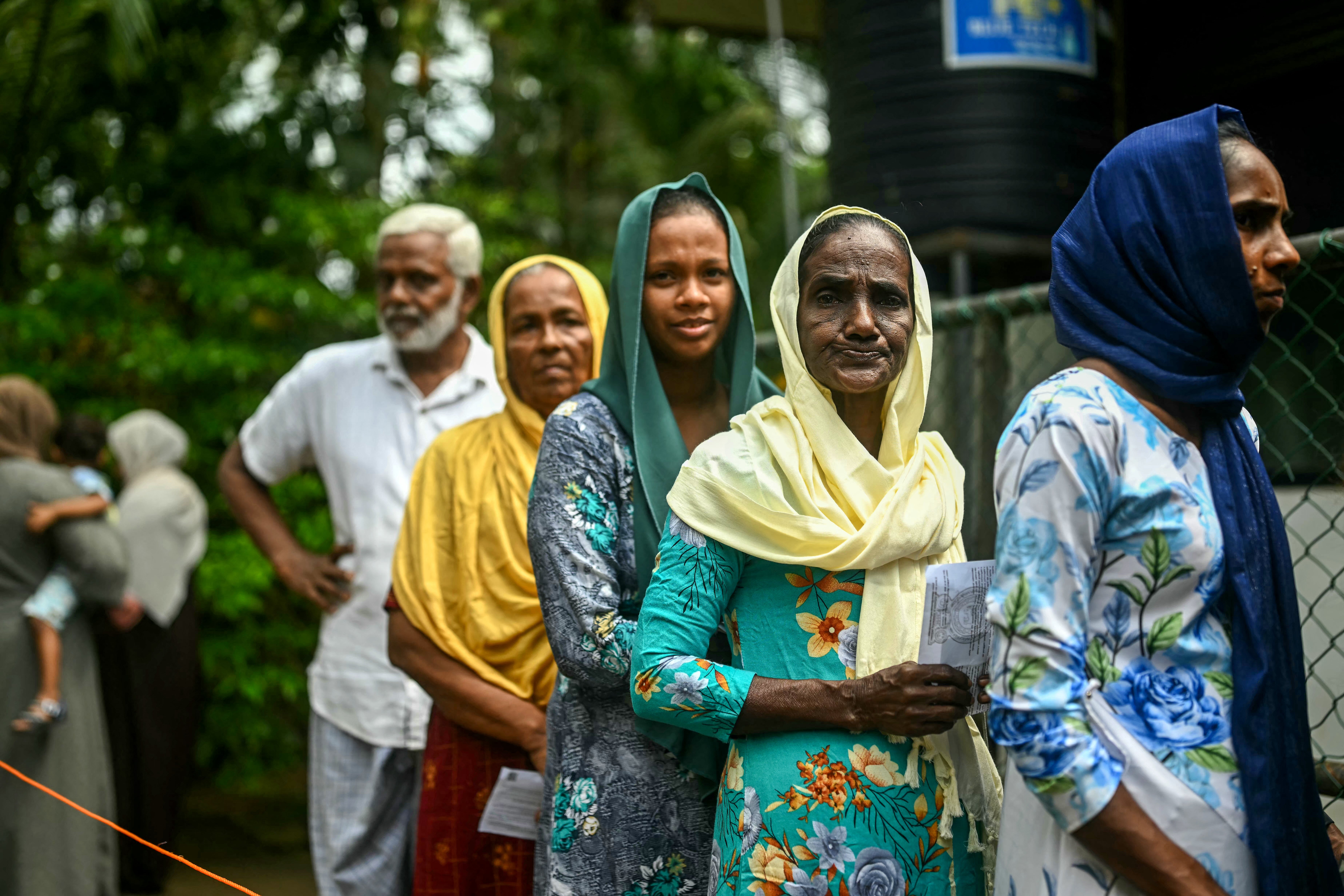 Sri Lankans wait in a queue to cast their ballots in Galle on 21 September 2024