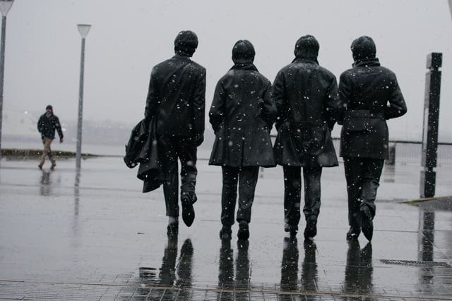 Snow falls around the Beatles statue at Pier Head in Liverpool (Peter Byrne/PA)