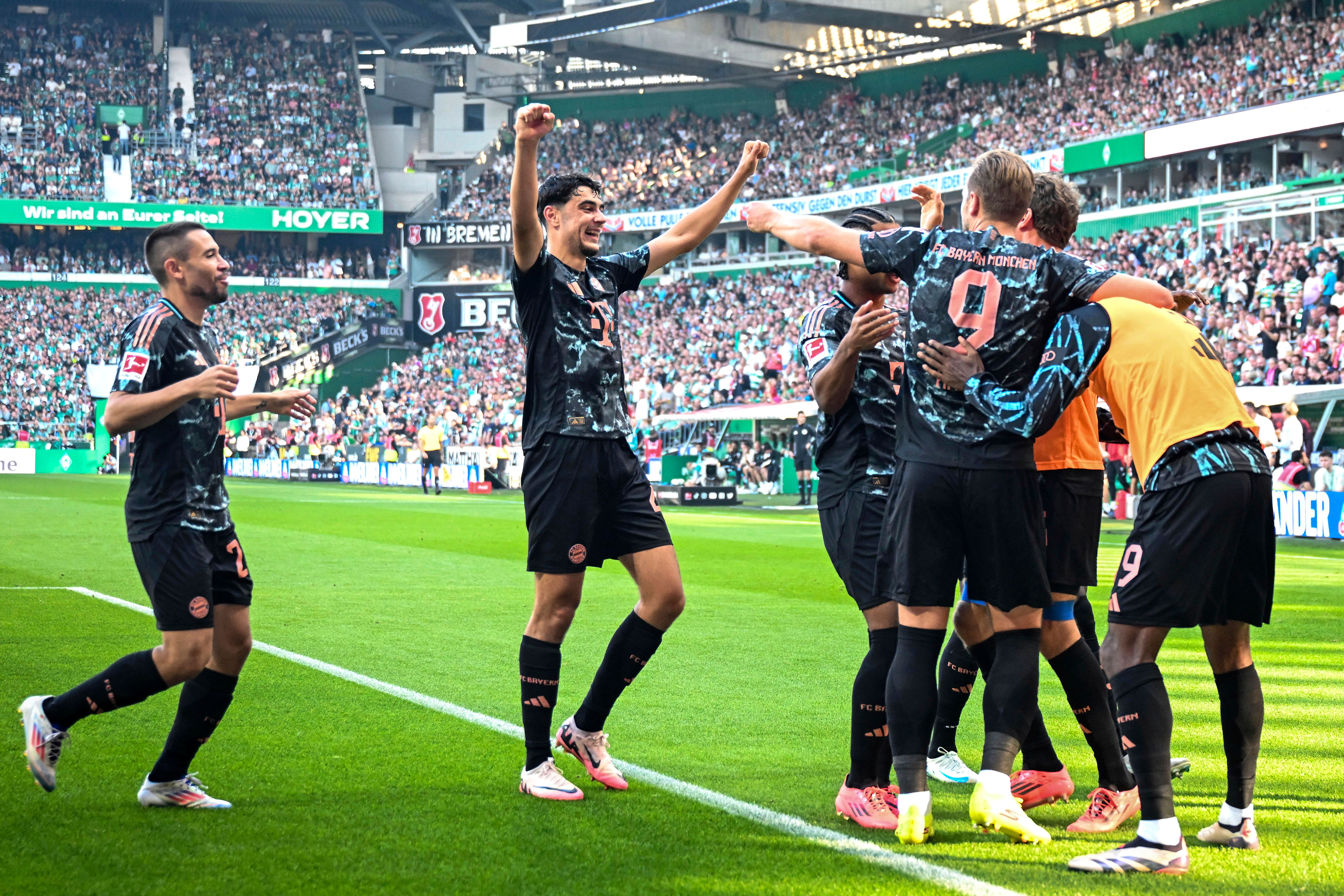 Harry Kane is congratulated by team-mates after scoring for Bayern Munich against Werder Bremen (Sina Schuldt/dpa via AP)