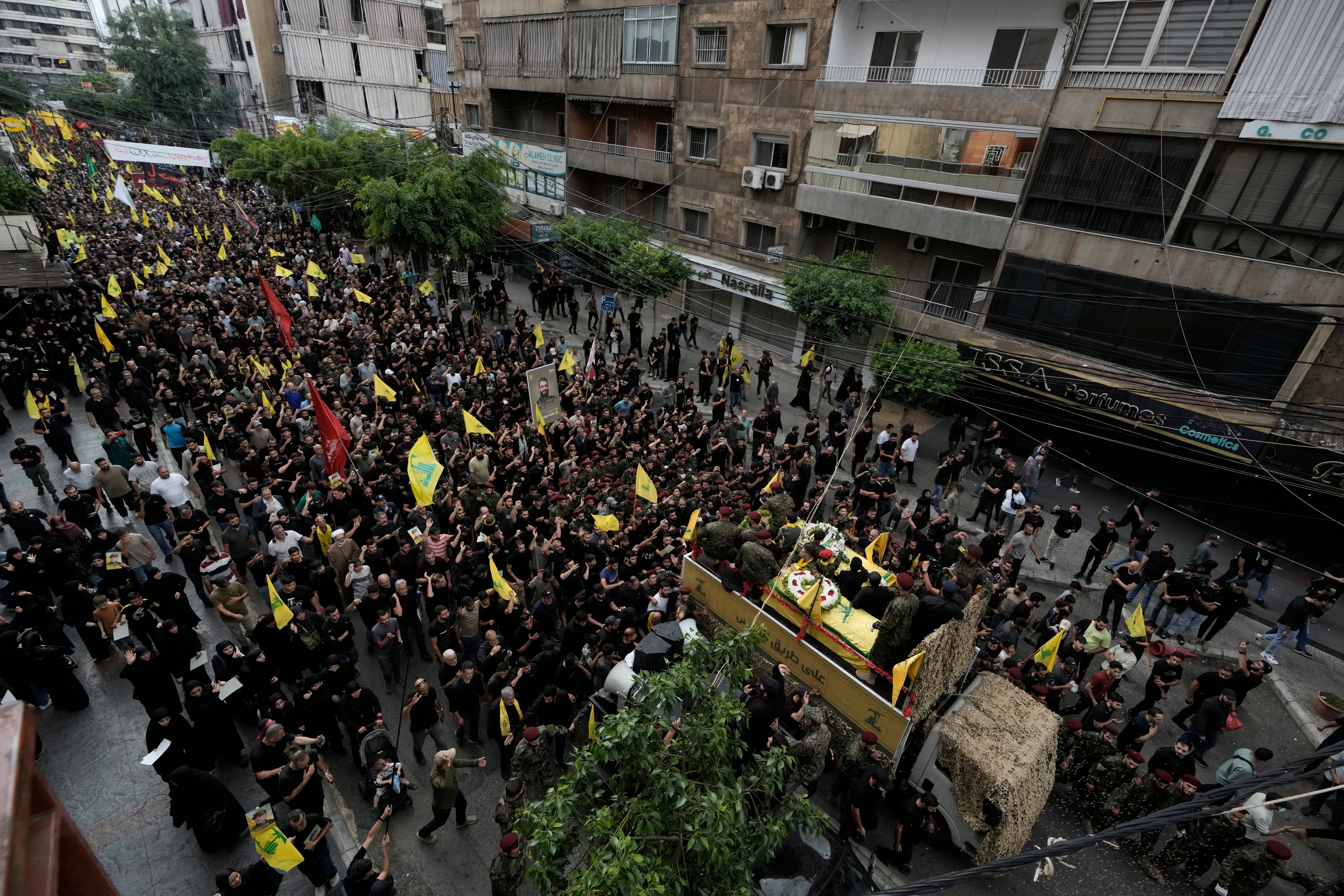 Hezbollah supporters march behind the hearse carrying the coffins of Hezbollah commander Ibrahim Akil and militant Mahmoud Hamad during their funeral procession in Beirut