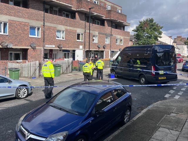 <p>Police officers work at the scene in Woolwich where a boy was fatally stabbed on Sunday</p>