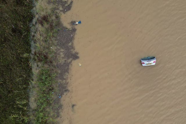 The open boot of a car is visible above the water where the vehicle is submerged in flood water on the A421 in Marston Moretaine, Bedfordshire (Joe Giddens/PA)