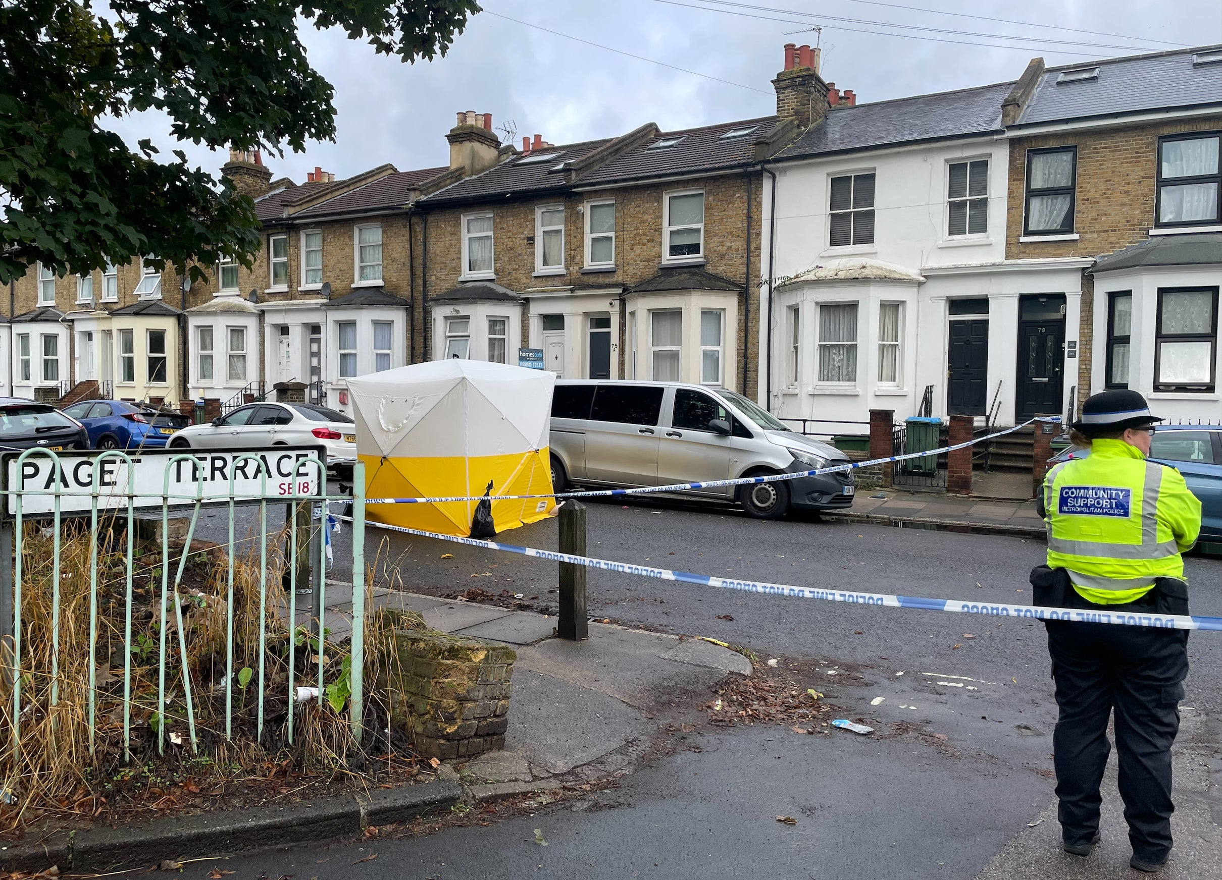 A Metropolitan Police officer stands near a police cordon and forensic tent on Paget Terrace, near the scene in Eglinton Road