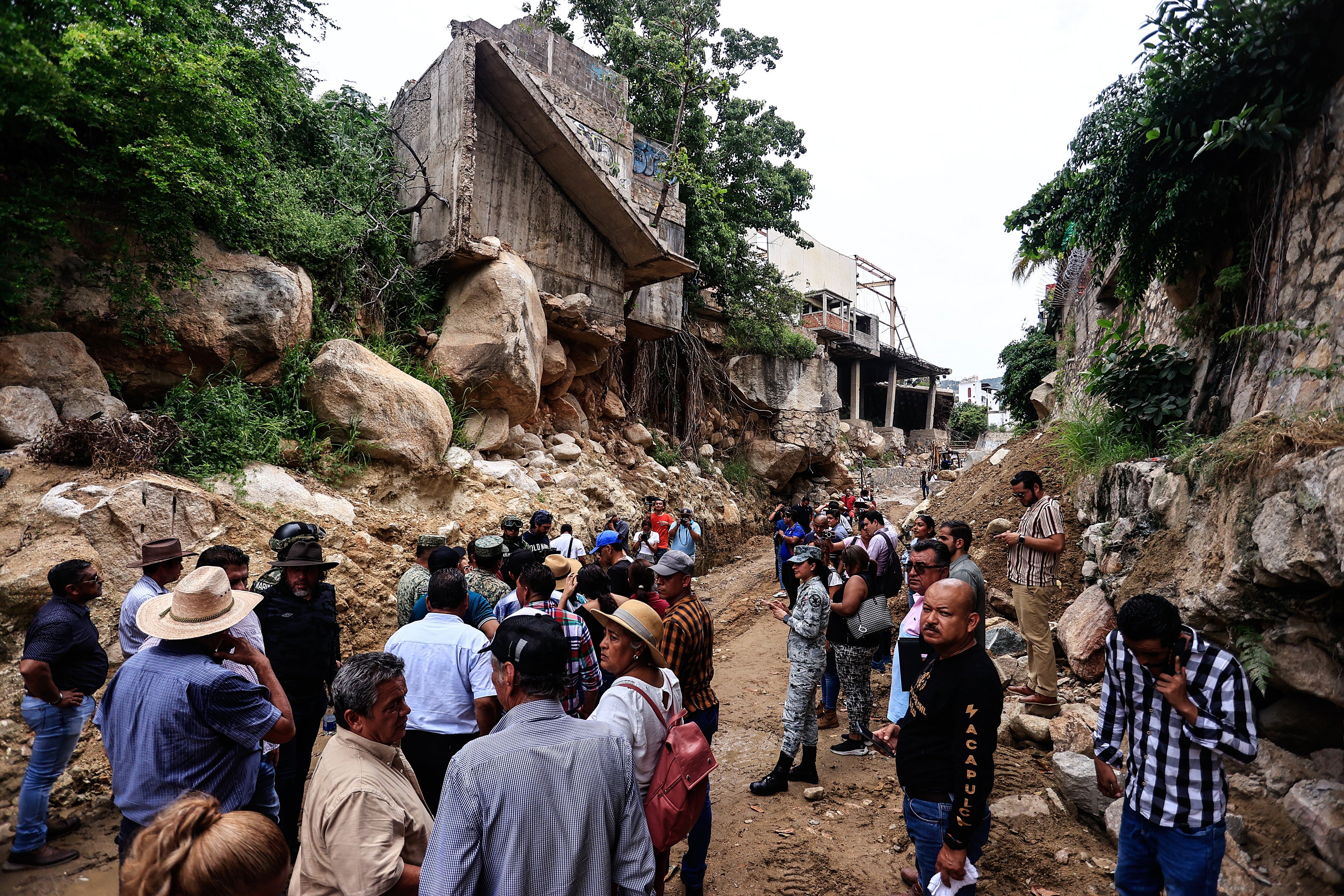 Municipal authorities and residents walk along the Camaron river channel where they supervise the cleaning of the channels ahead of the rains of hurricane 'John', in the city of Acapulco