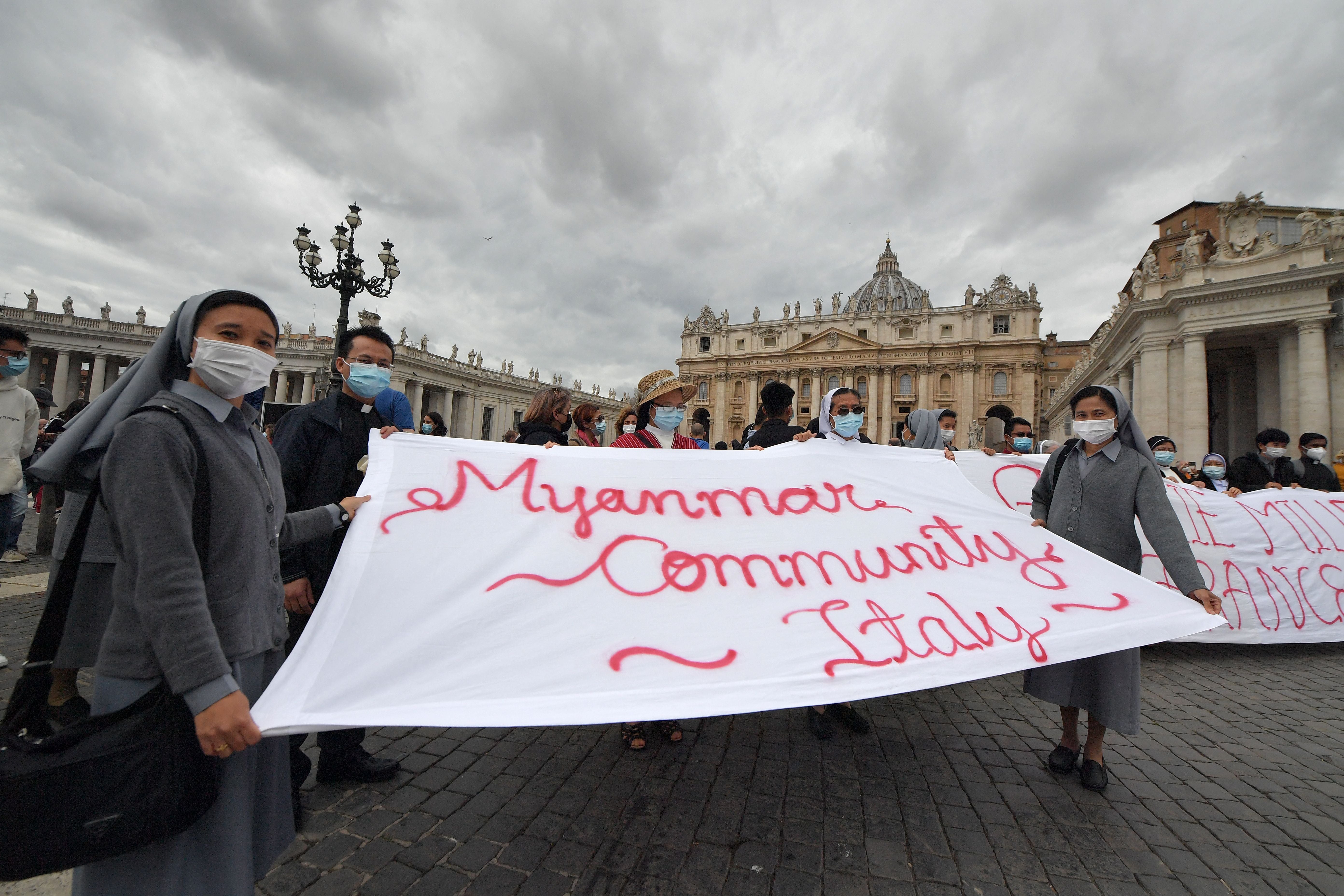 Members of the community of Italy’s faithful of Myanmar hold a banner during the Pope’s weekly Angelus prayer