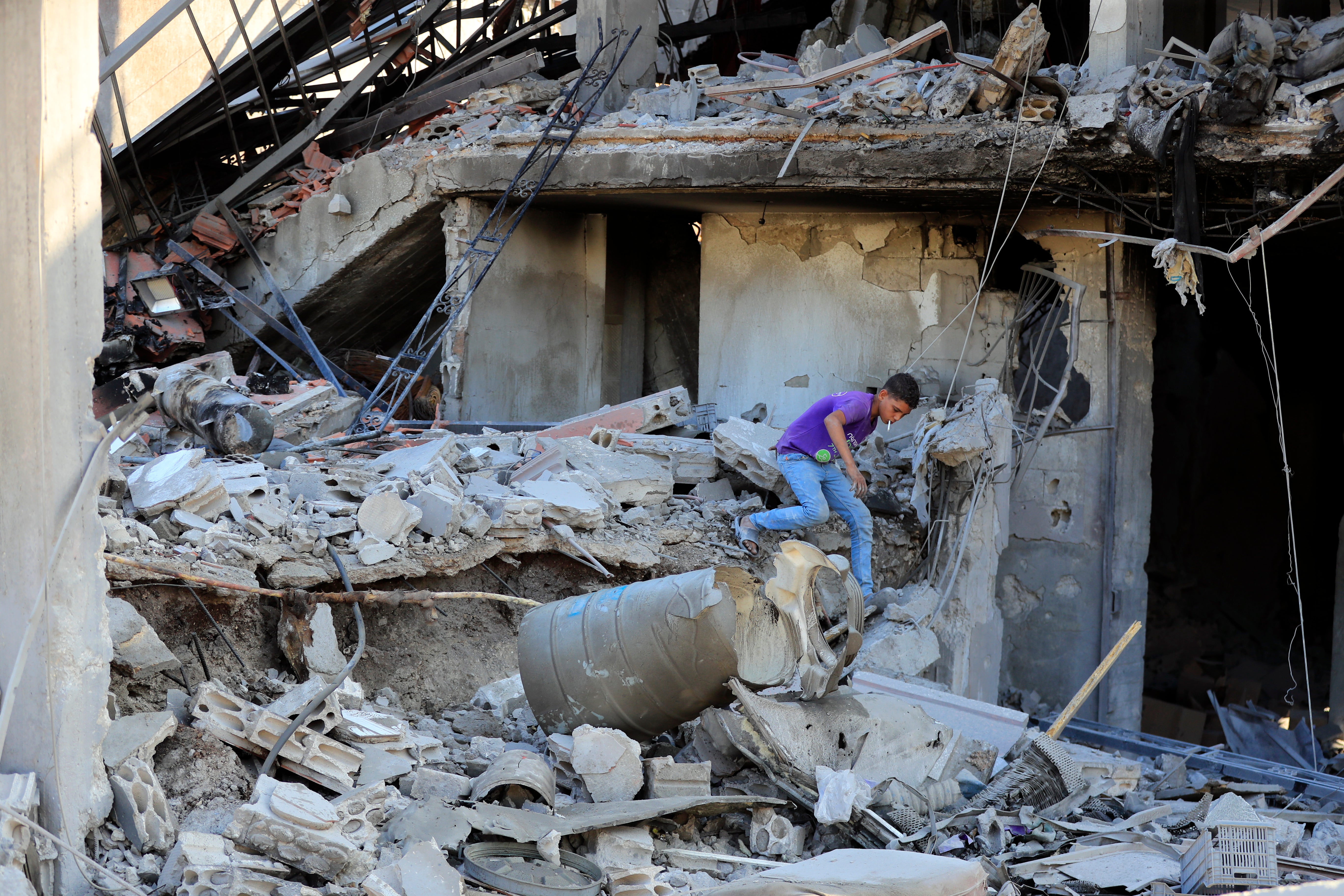 A boy inspects damage following Israeli airstrike in southern village of Akbieh