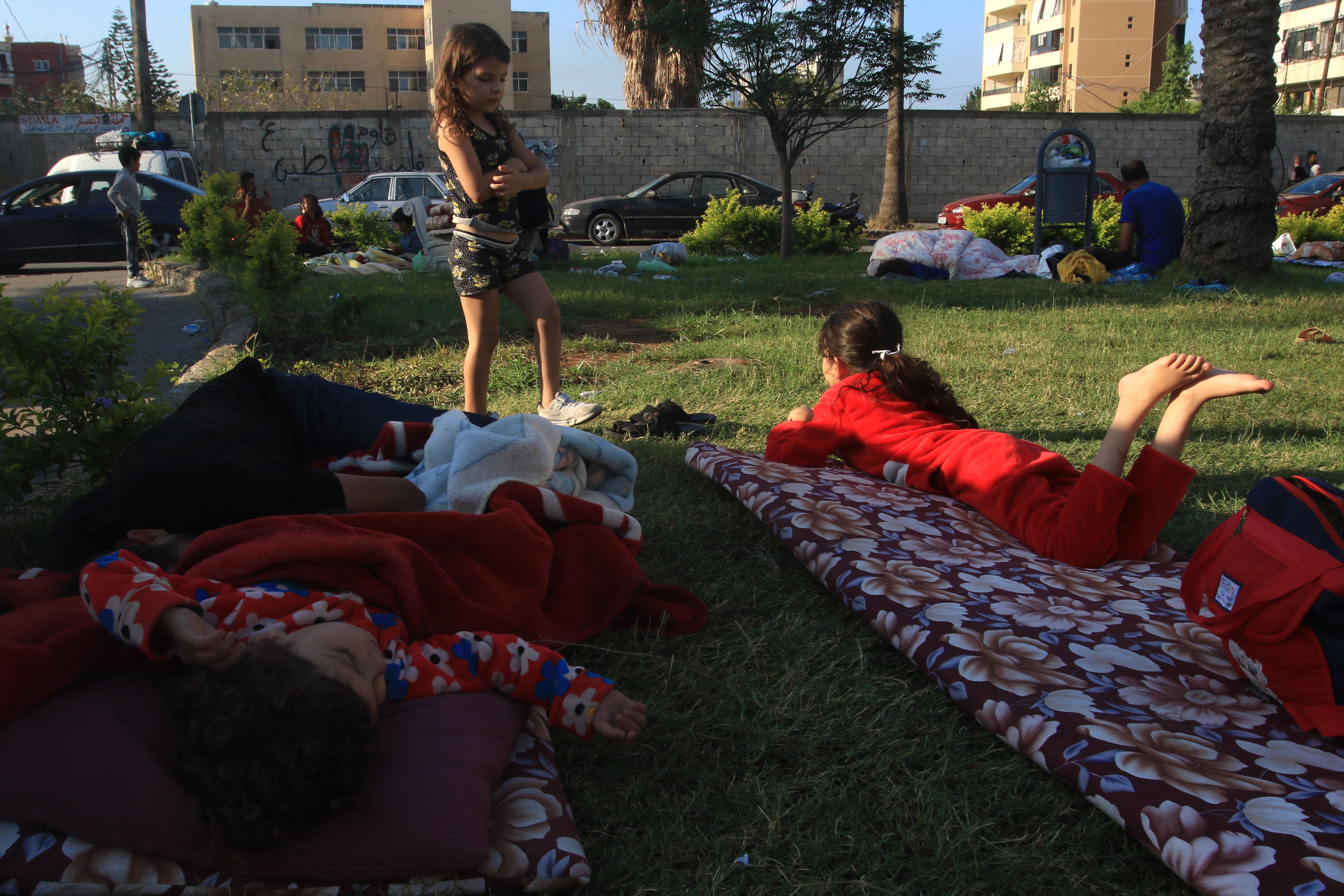 Children sleep in the park after fleeing their southern Lebanon homes