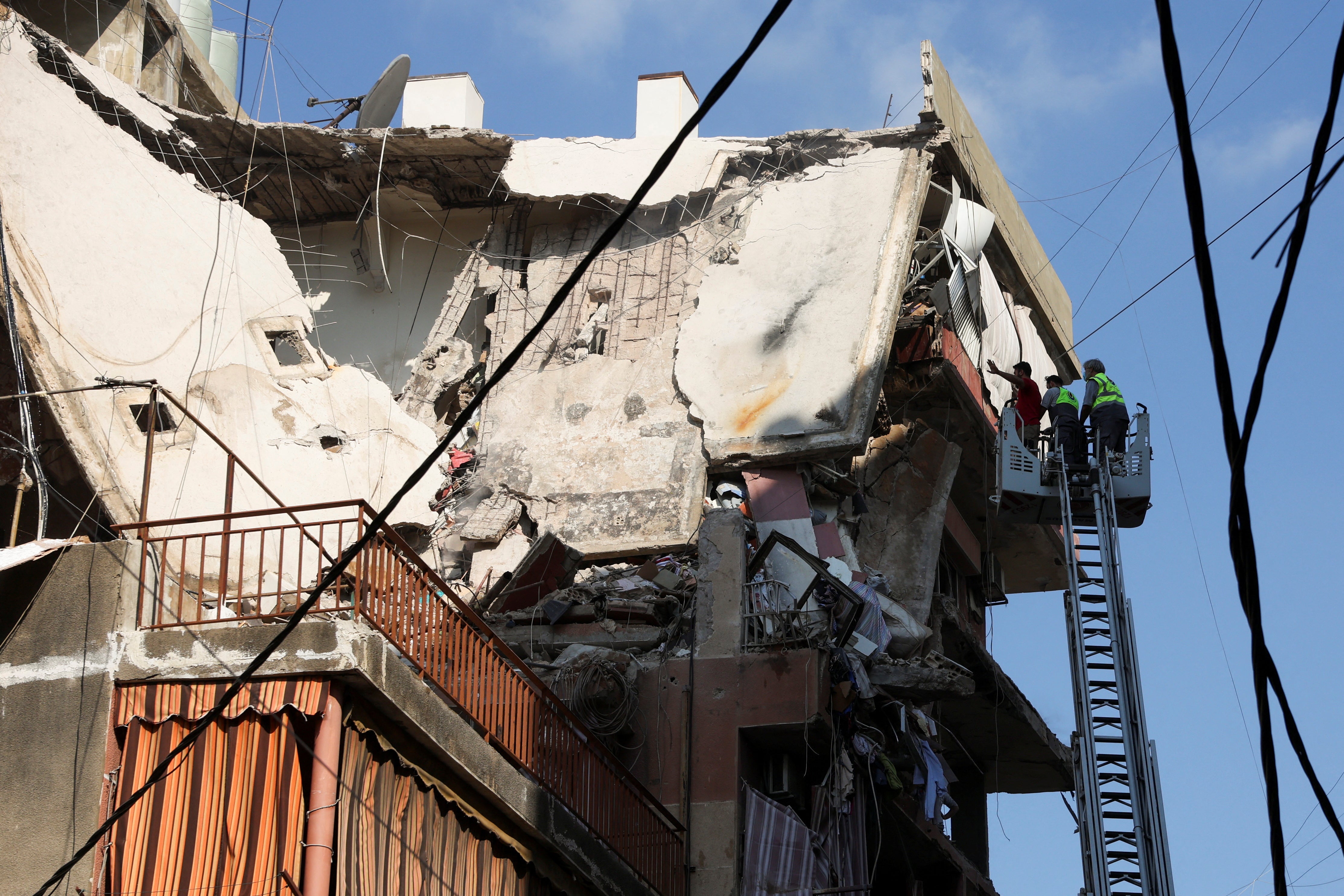 People gather near the site of an Israeli strike in Beirut's southern suburbs