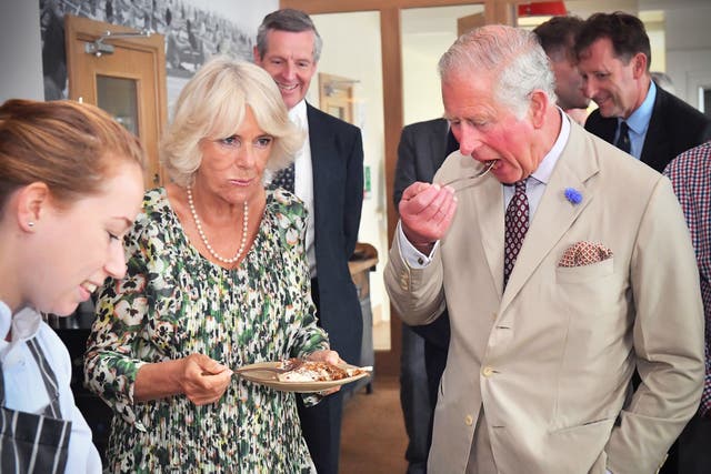 <p>The King and Queen eating carrot cake to celebrate her 71st birthday during a visit to the Isles of Scilly in 2019</p>