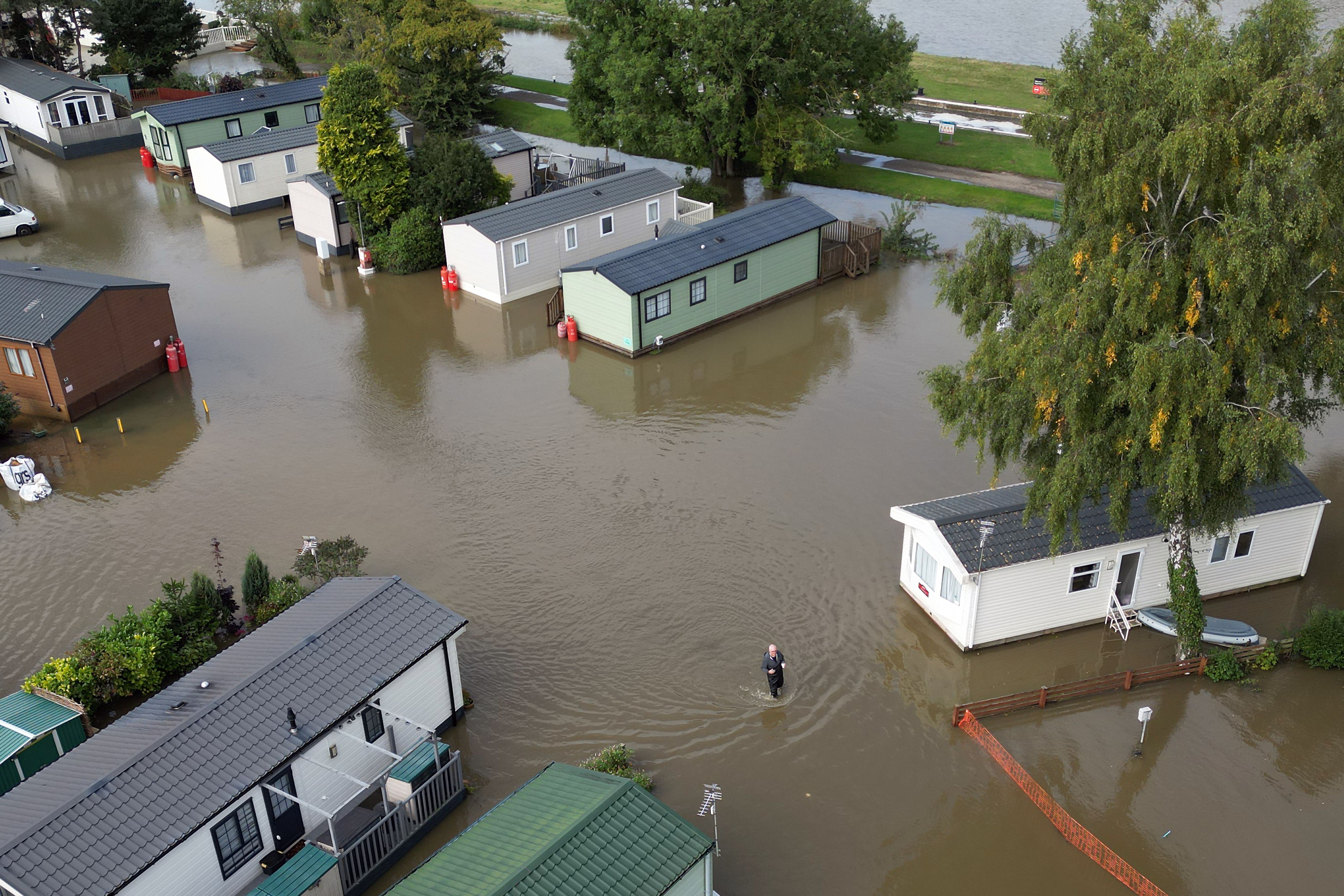 A man wades through floodwater at Cogenhoe Mill Holiday Park in Northamptonshire, which is next to Billing Aquadrome holiday park. Picture date: Tuesday September 24, 2024. (Joe Giddens/PA)