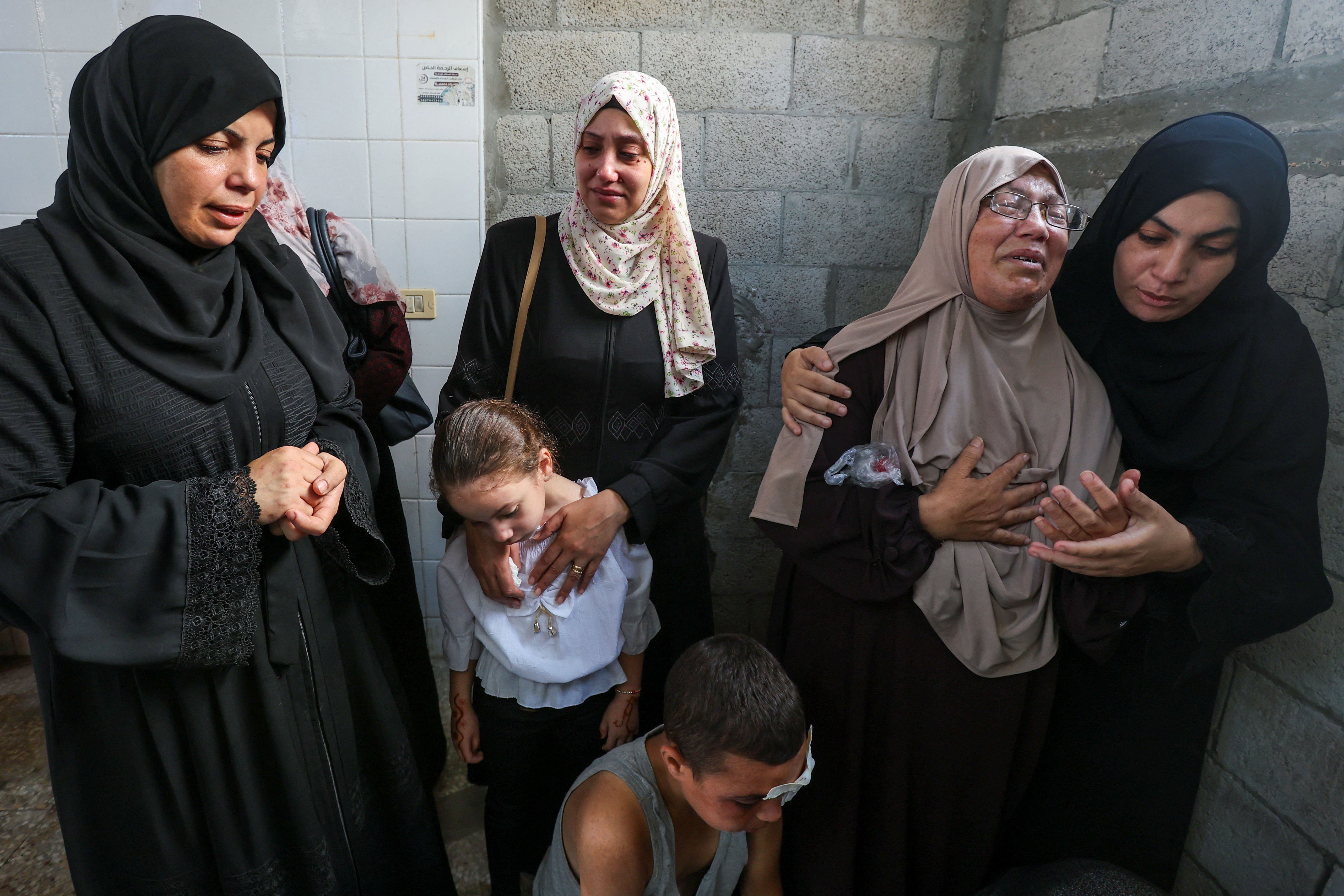 Palestinians mourn loved ones killed in Israeli strikes, in Deir Al-Balah in the central Gaza Strip