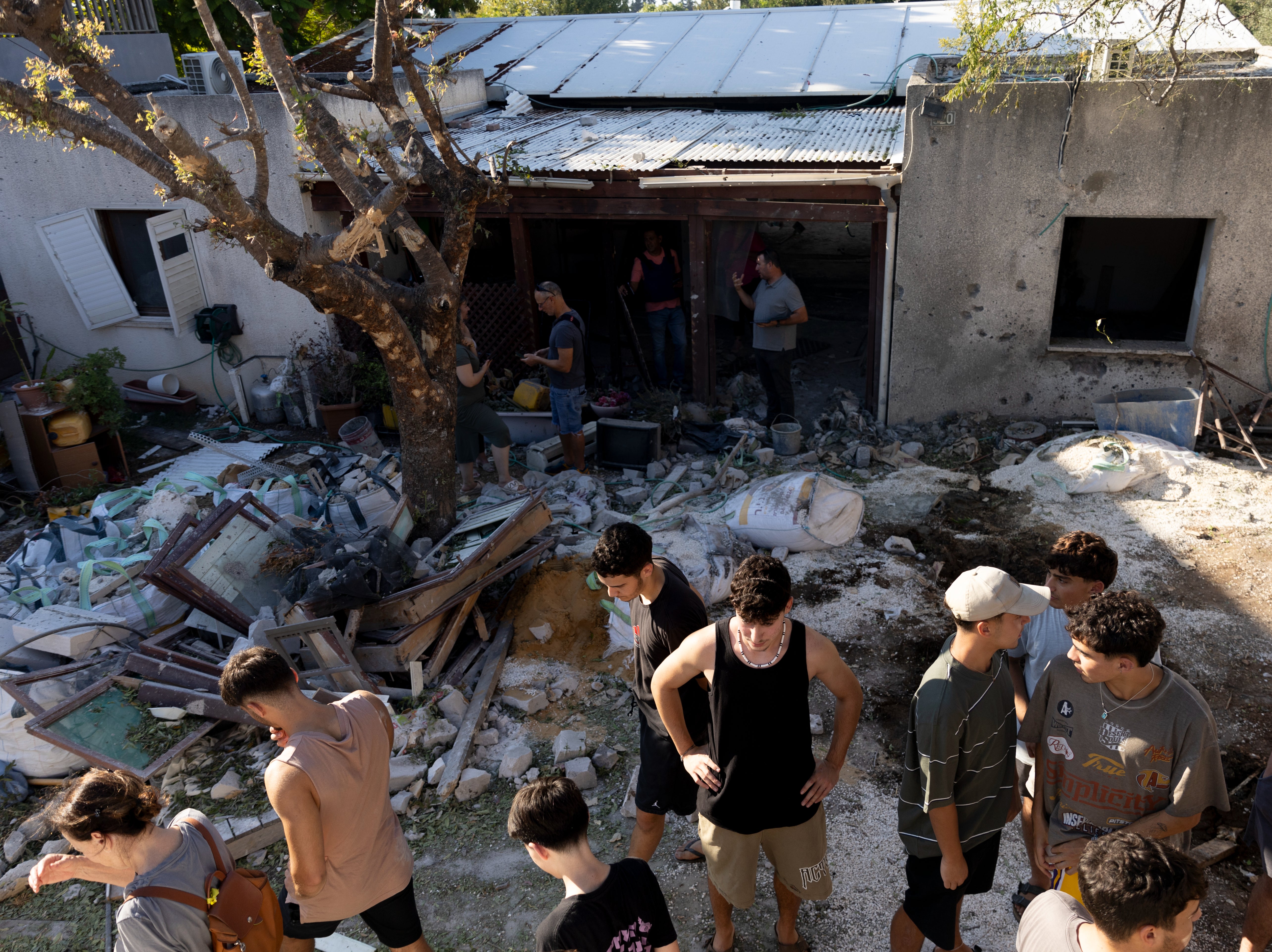 People inspect a house hit by a rocket fired from Lebanon on Wednesday