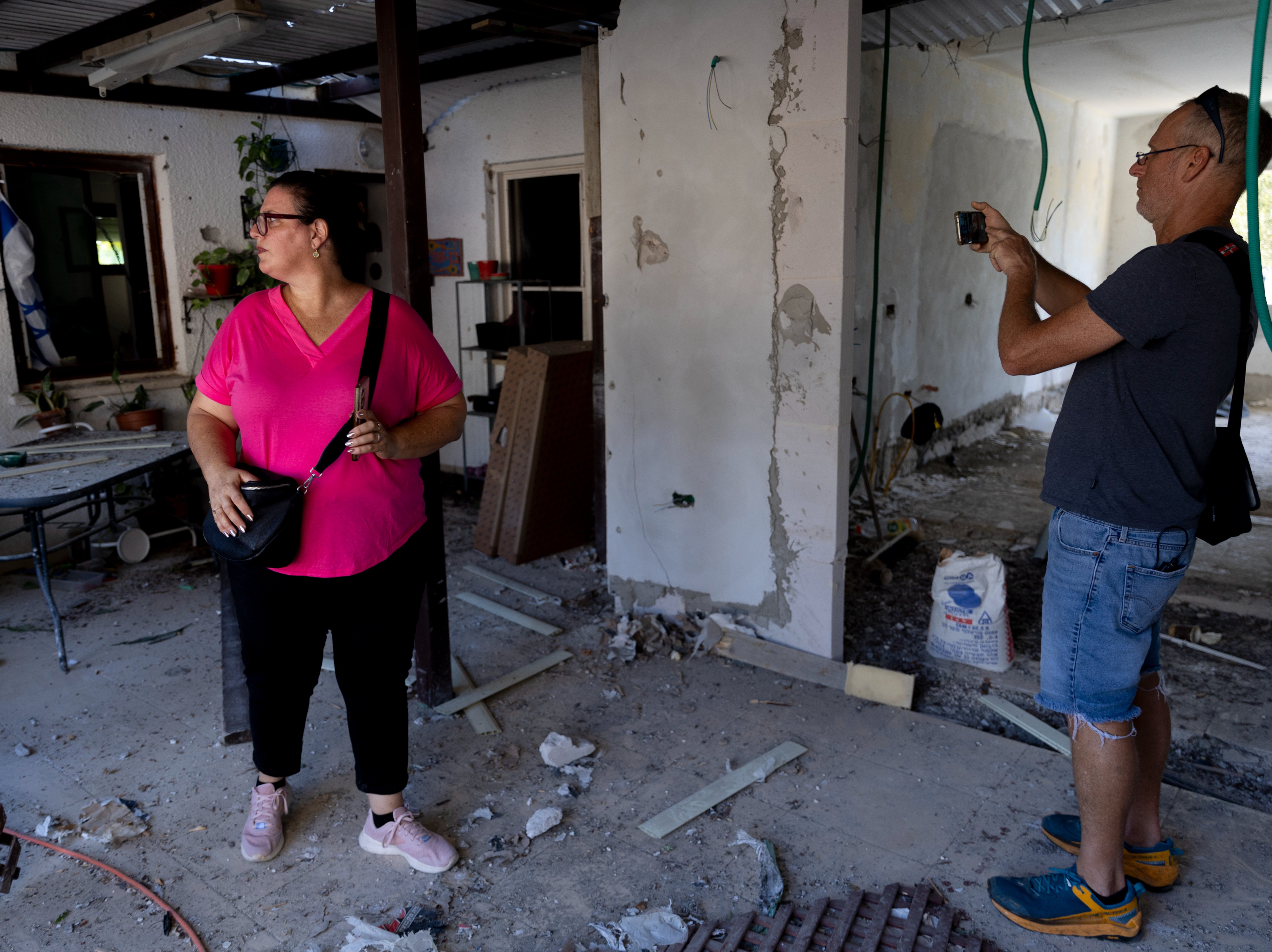 People inspect a house hit by a rocket fired from Lebanon on Wednesday